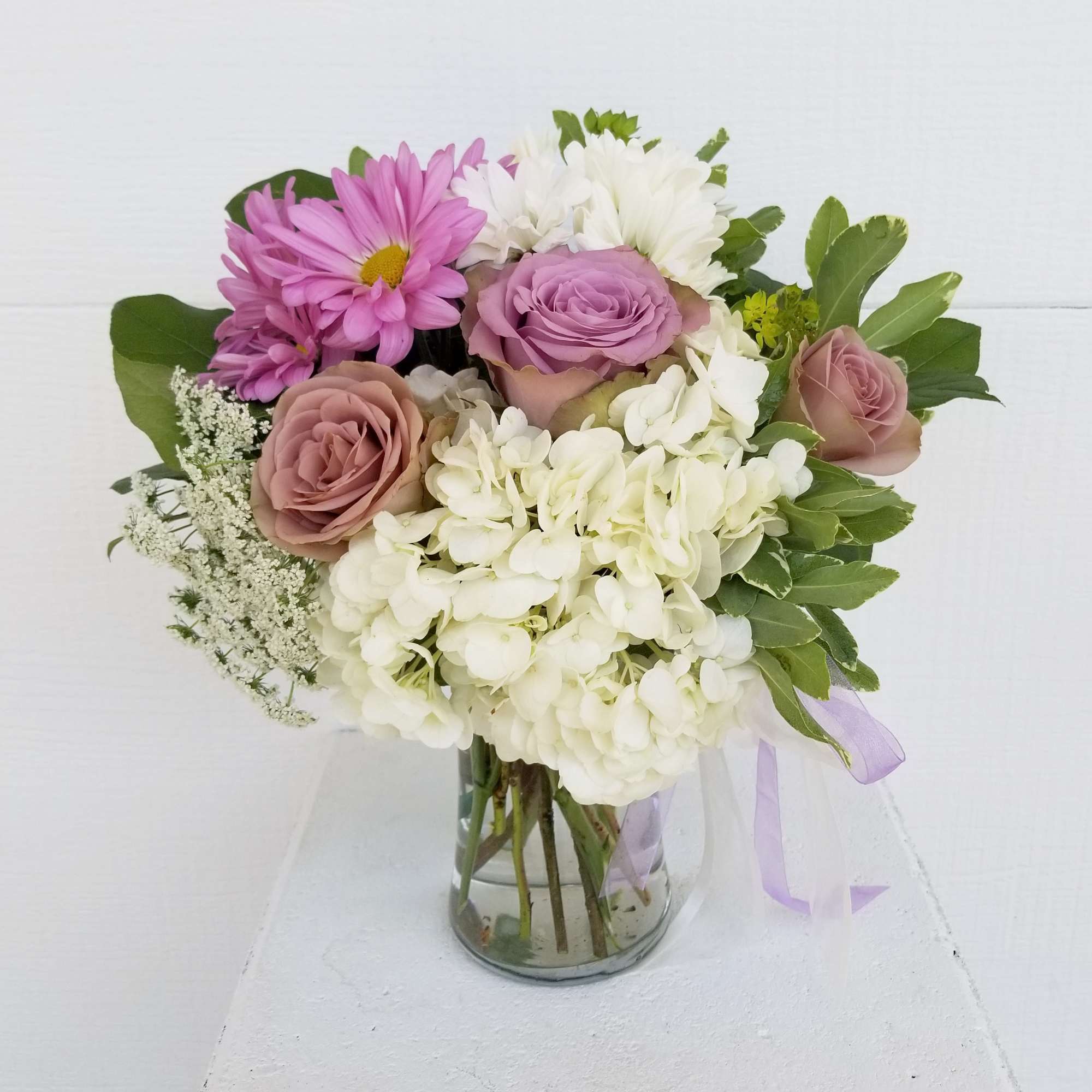 Small garden arrangement of lavender and white Daisy&#039;s with roses and hydrangea