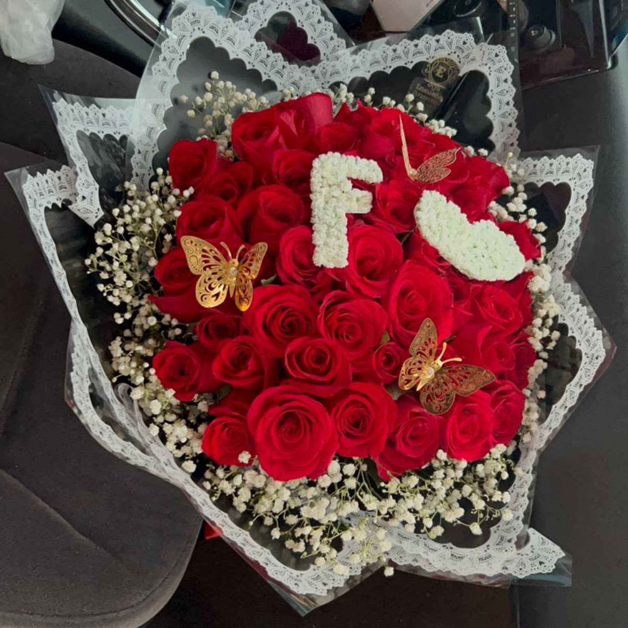 Ramo buchon elaborado con rosas rojas, gipsofilia y mariposas artificiales.