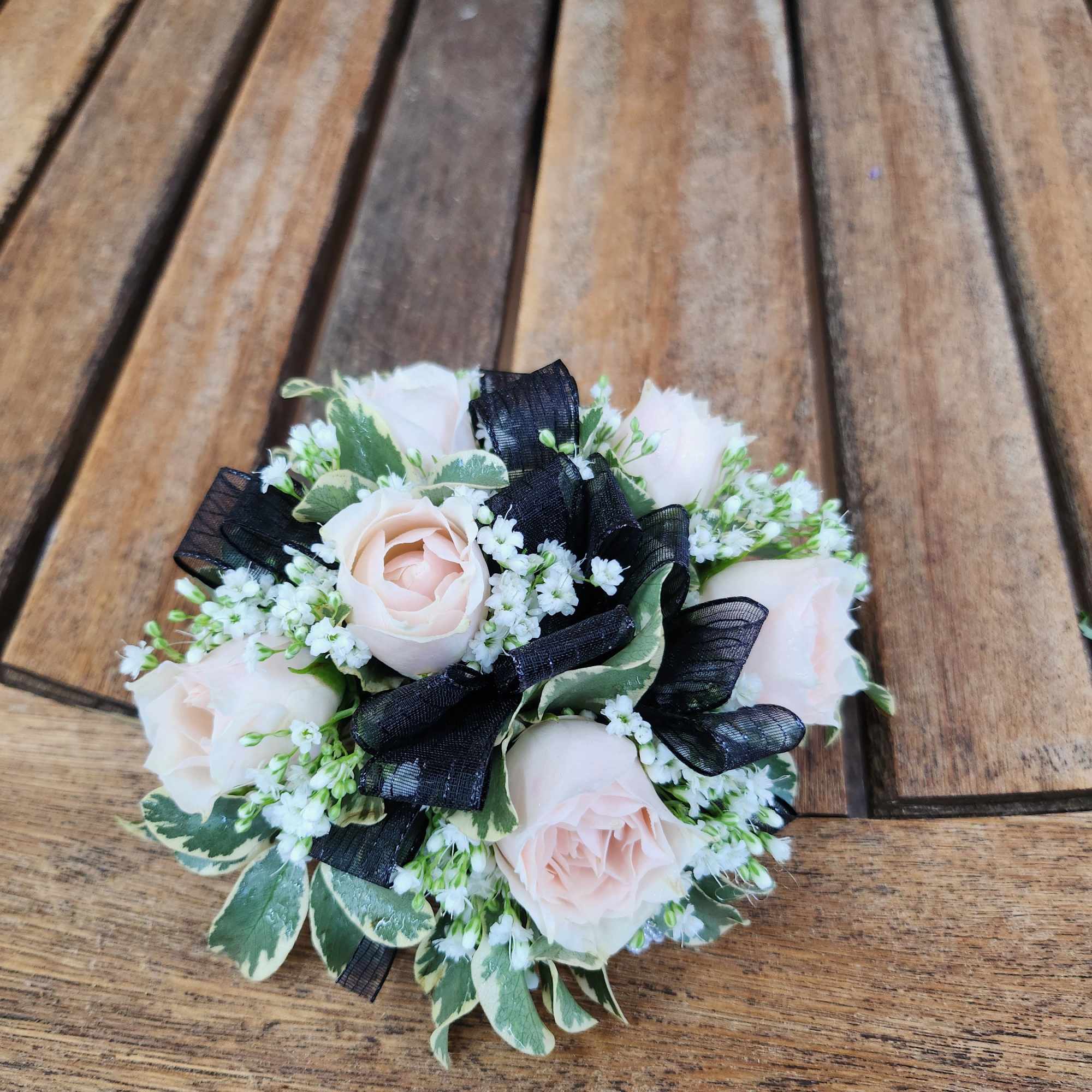 Wrist Corsage With Blush Spray roses, greenery, filler flower and black ribbon.