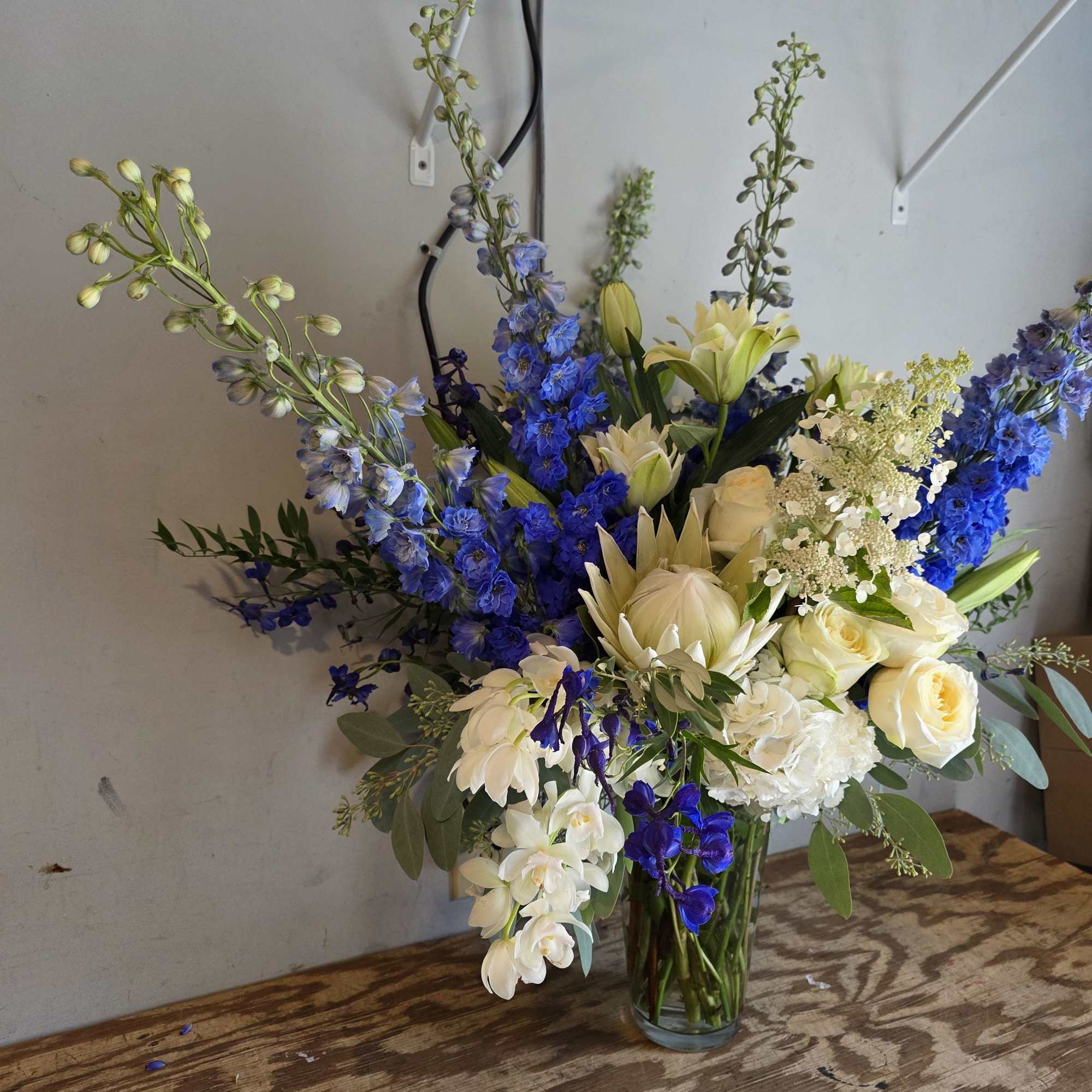 Royal Blue &amp; White Grande Arrangement
Commanding attention with its striking palette, this