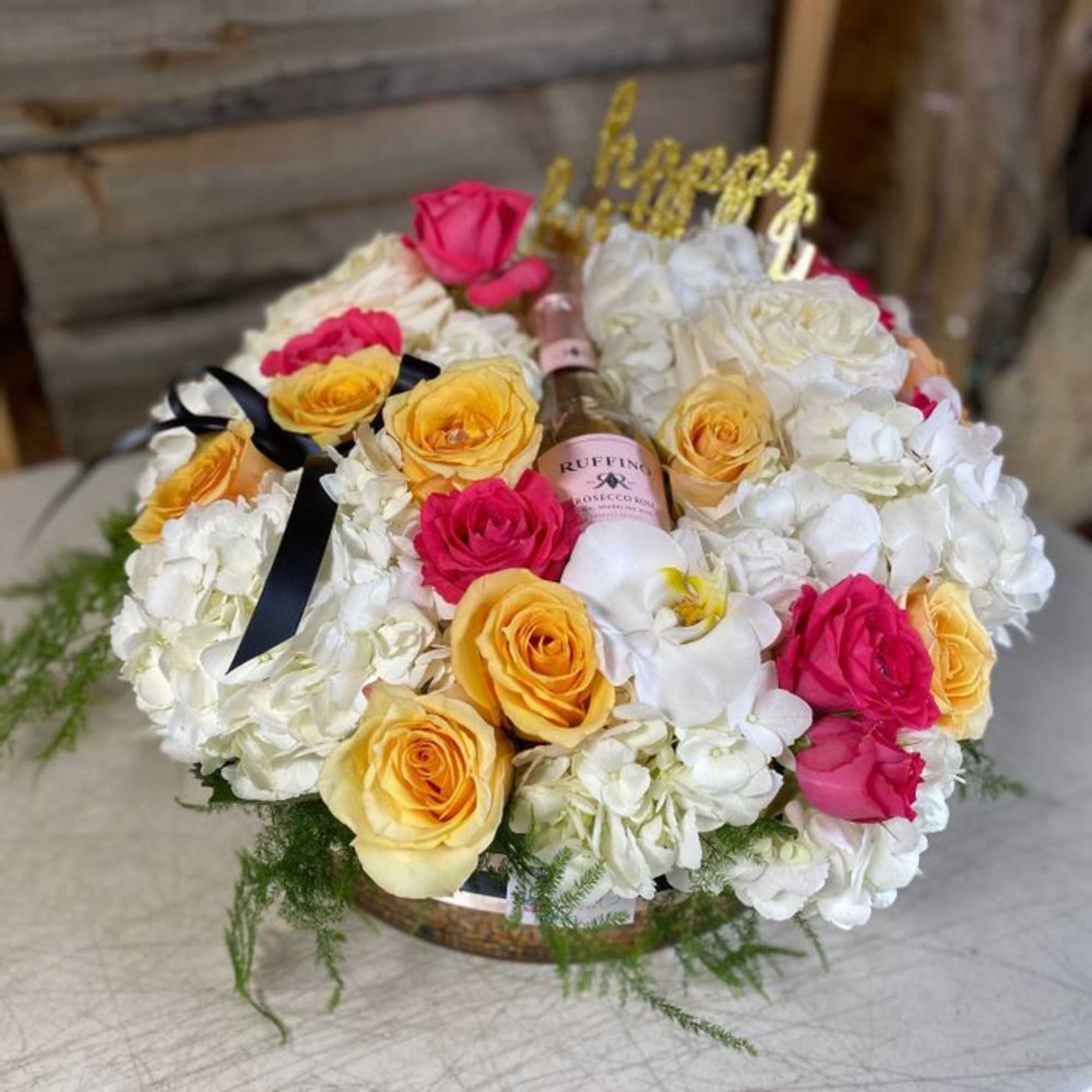 This arrangement includes roses, hydrangeas ,and other seasonal blooms. This is a