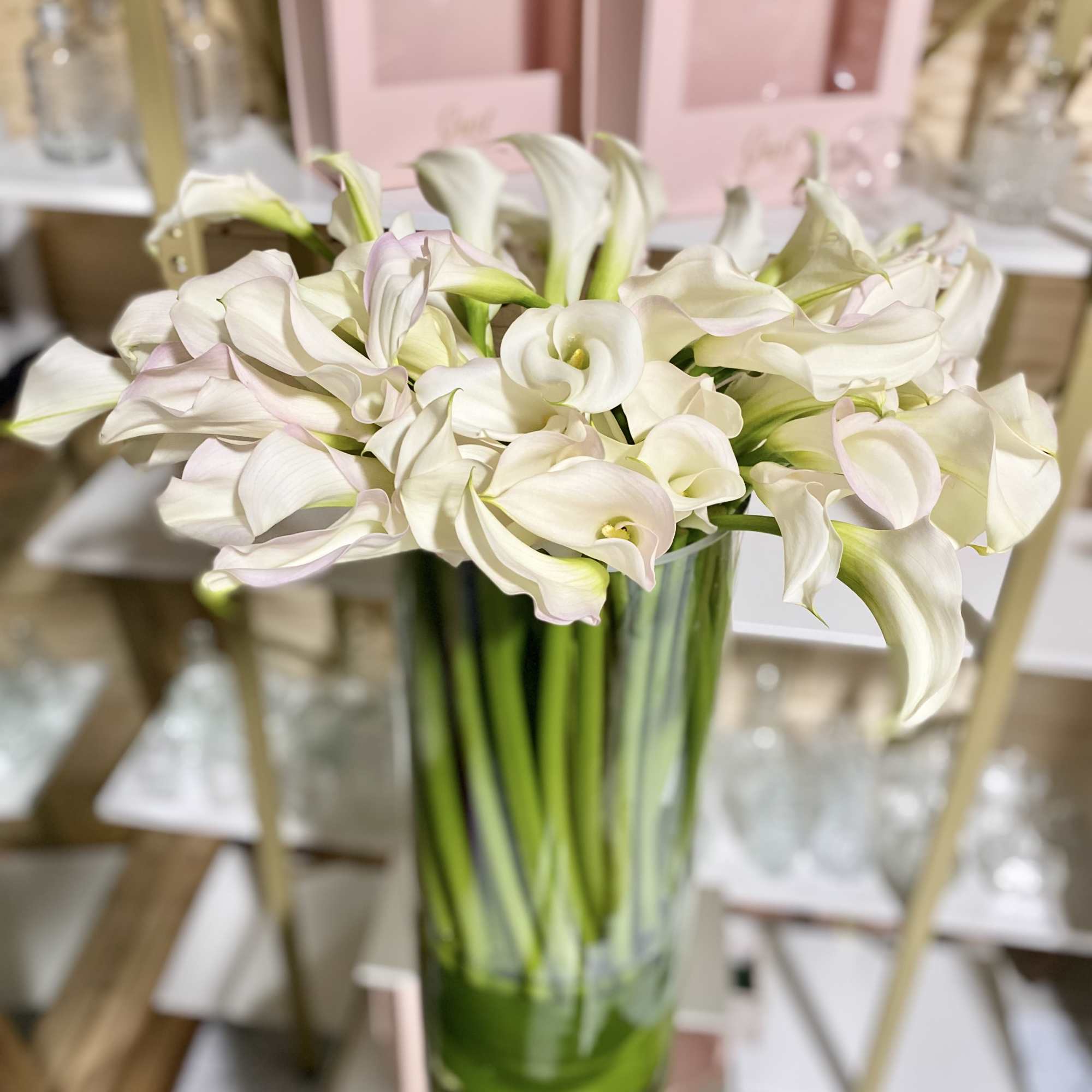 Monochromatic floral with all white Calla Lily&#039;s in glass vase . Simple