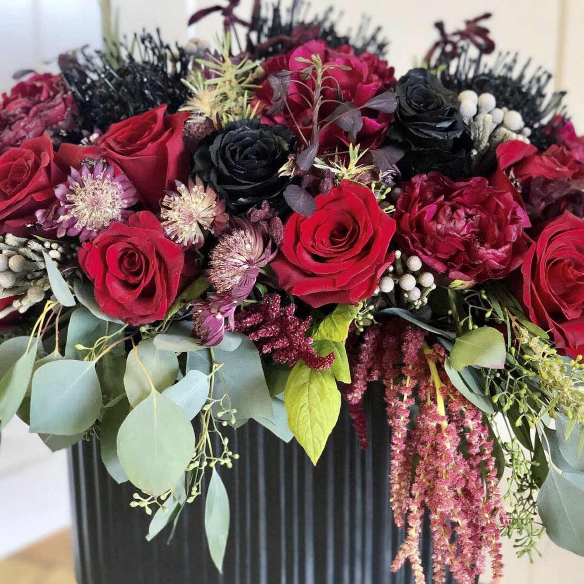 A spooky delight of black and red florals in a black ceramic