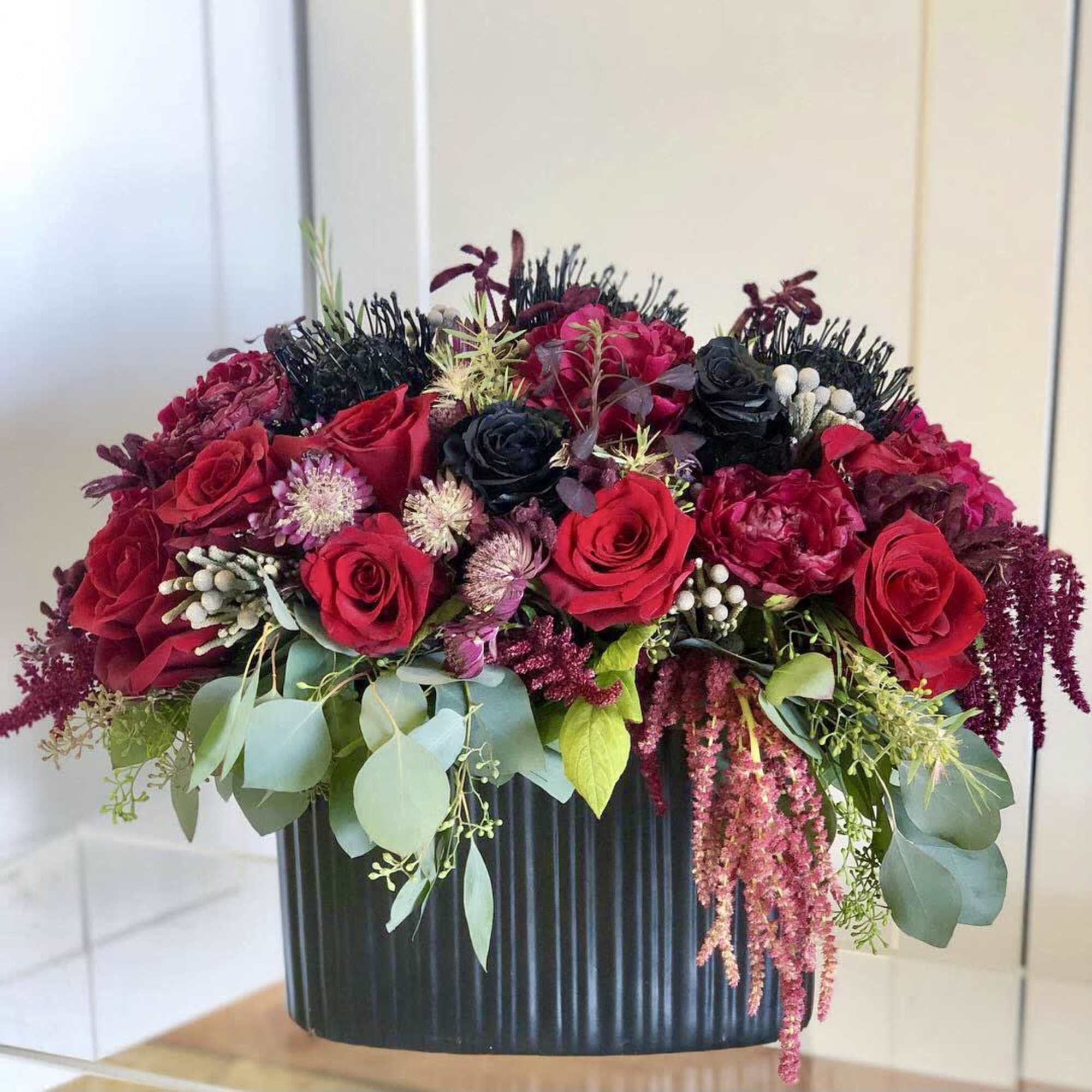 A spooky delight of black and red florals in a black ceramic