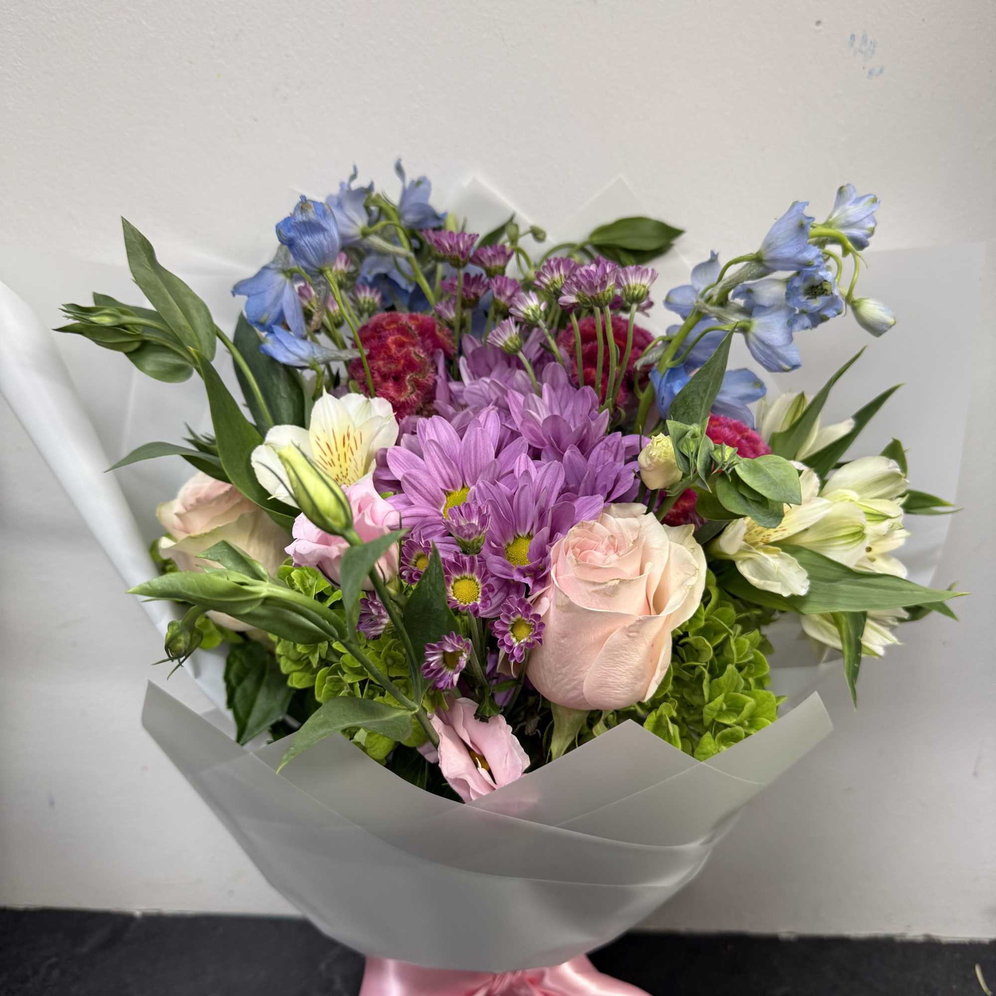 A graceful hand-tied bouquet featuring soft blush roses, lavender mums, fresh white