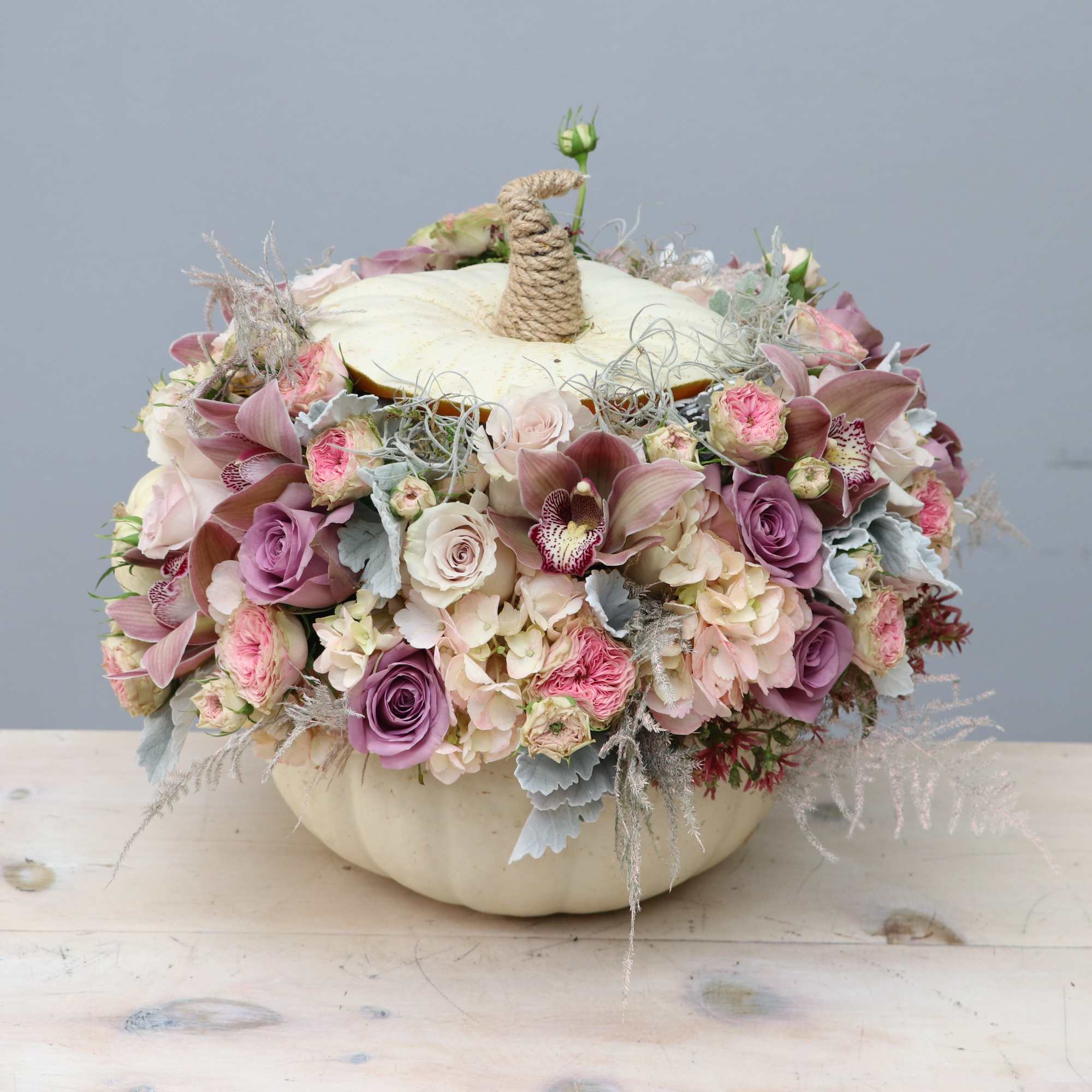 With a beautiful collection of pastels and pinks, this unique pumpkin arrangement