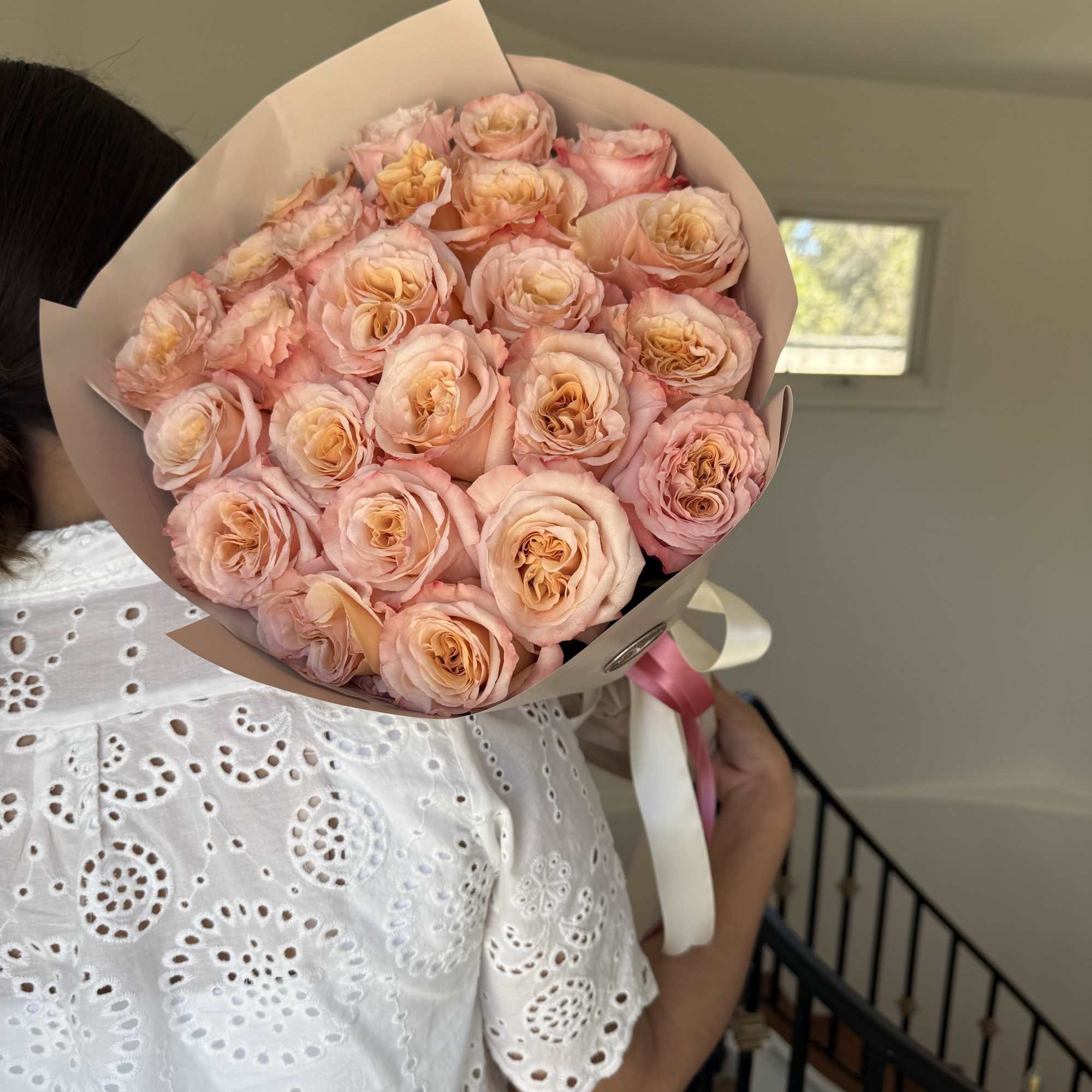 A fresh and elegant wrapped bouquet of roses with soft pink petals A fresh and elegant wrapped bouquet of roses with soft pink petals