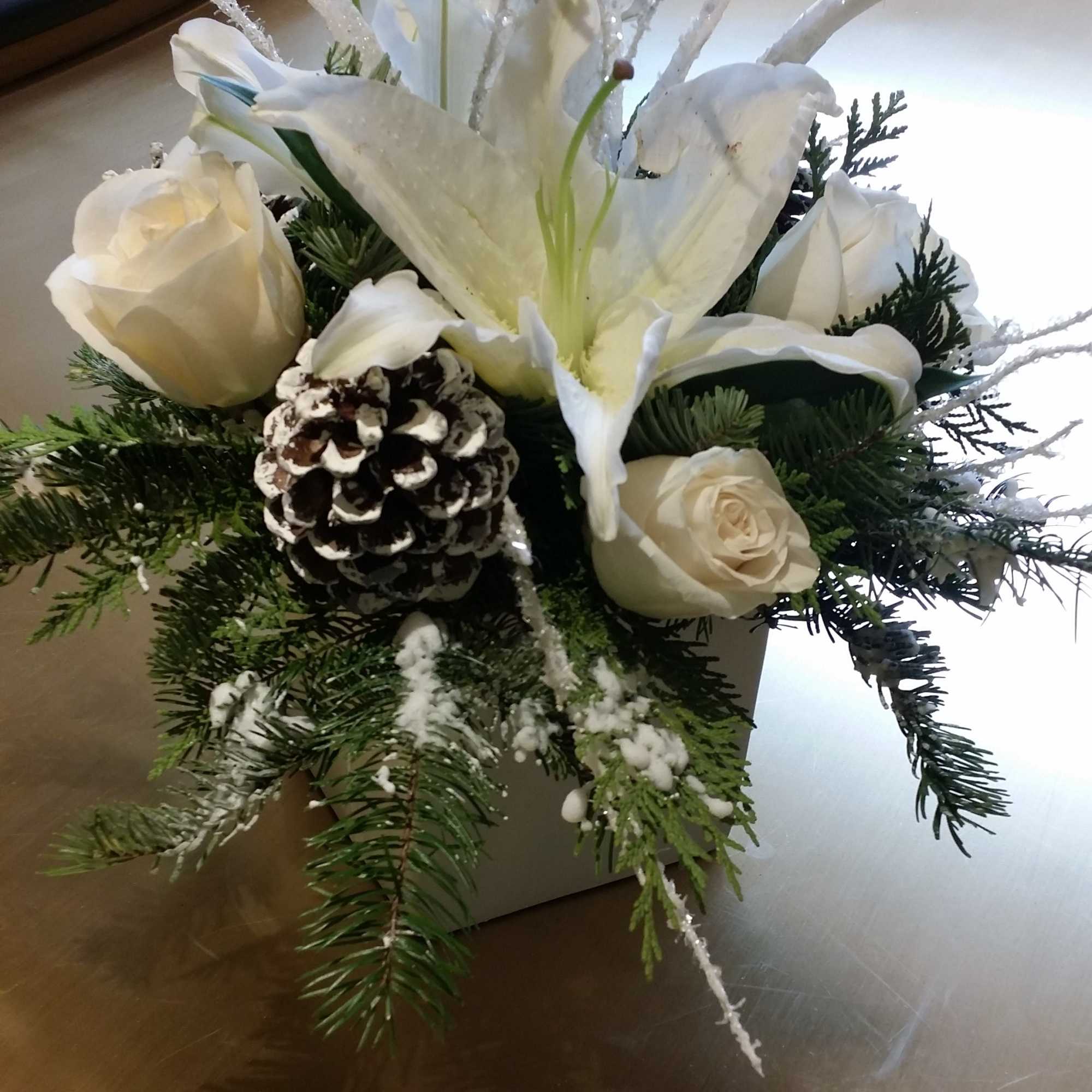 Christmas Greens with Casa Blanca Lilly&#039;s and White Roses with Pine Cones