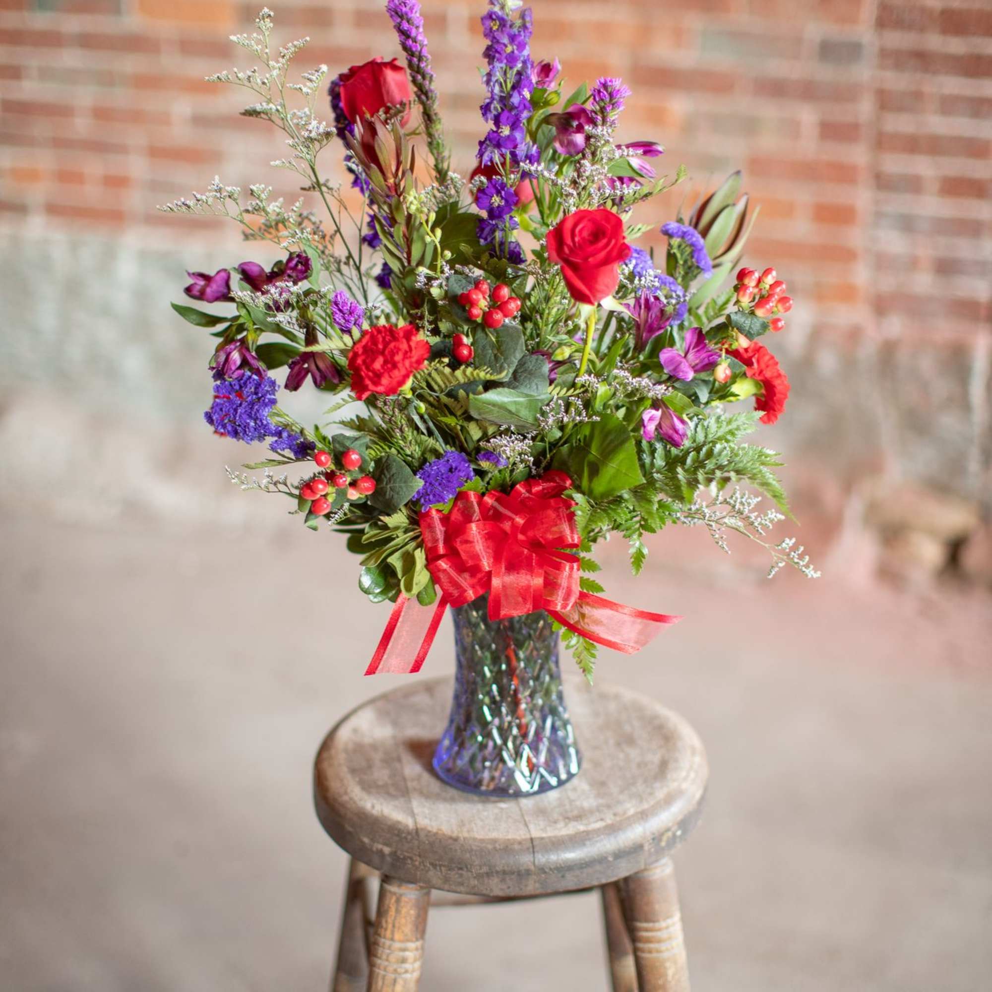 In a brilliant cut lavender vase are jewel toned beauties. Rich roses