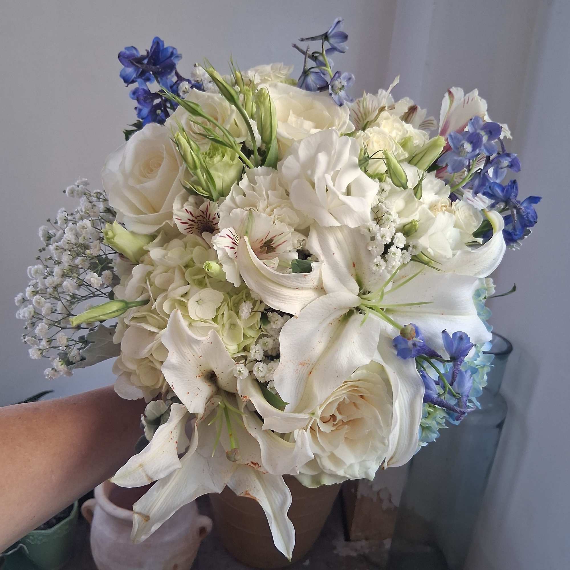 Magnificent white oriental lily, garden roses, white lisiantus, blue hydrangea and delphinium