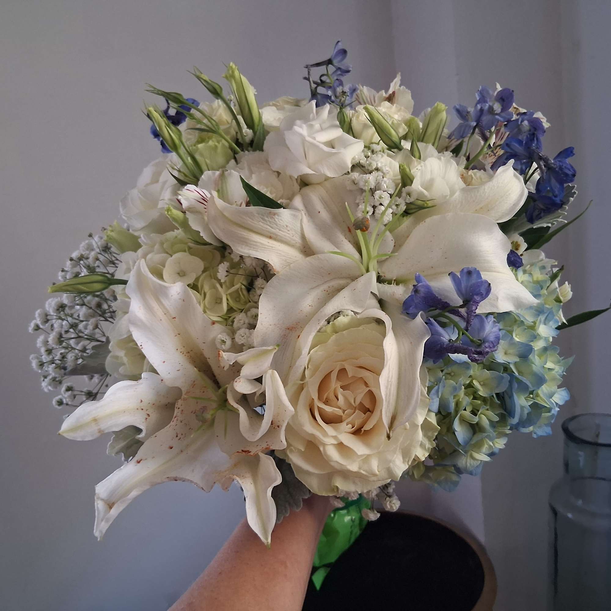 Magnificent white oriental lily, garden roses, white lisiantus, blue hydrangea and delphinium