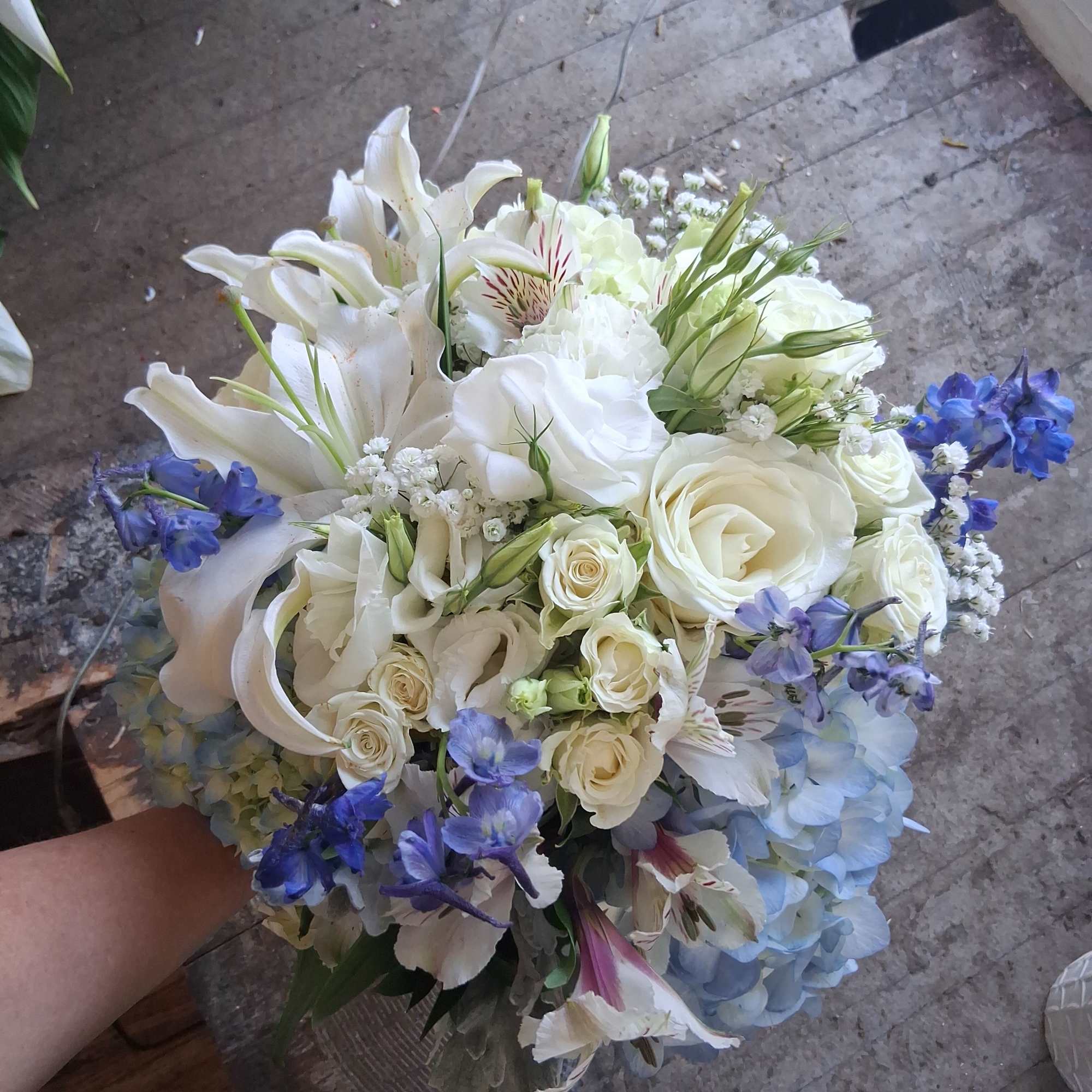 Magnificent white oriental lily, garden roses, white lisiantus, blue hydrangea and delphinium