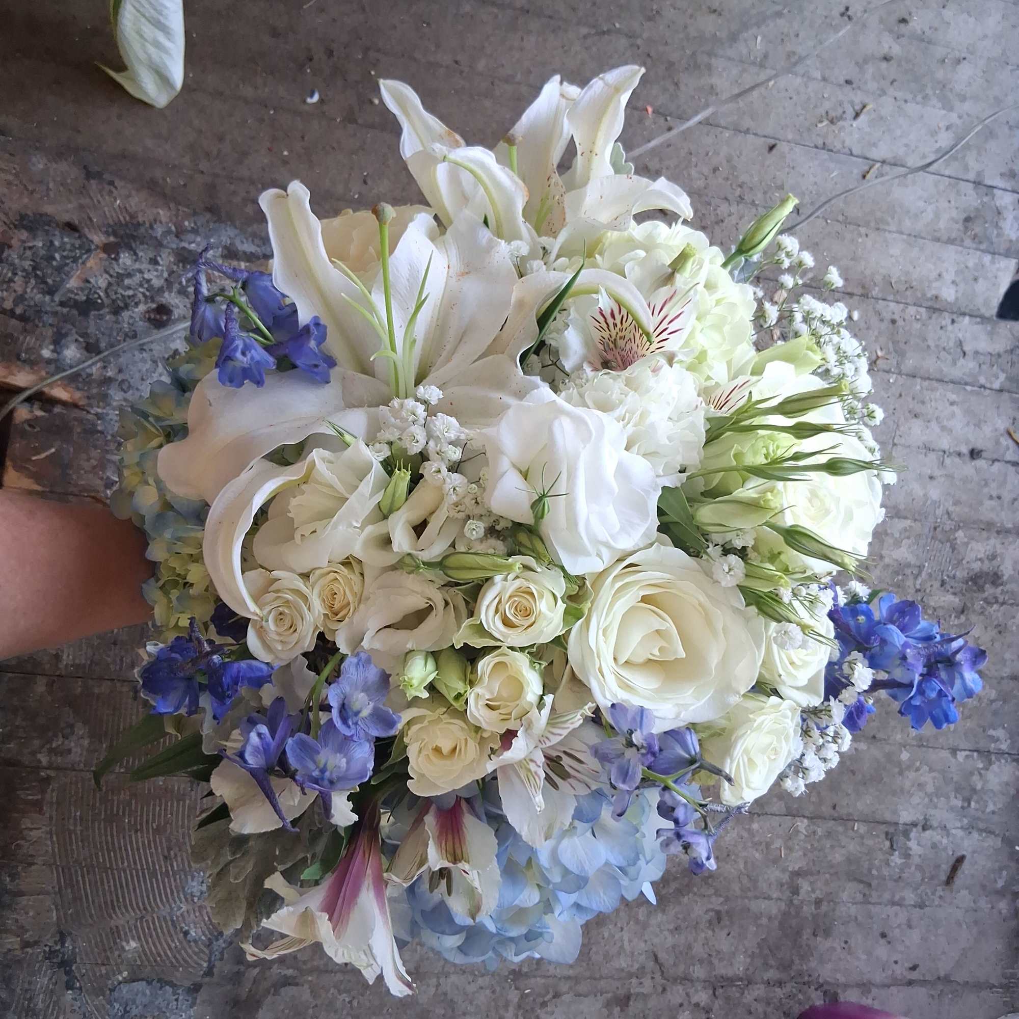 Magnificent white oriental lily, garden roses, white lisiantus, blue hydrangea and delphinium
