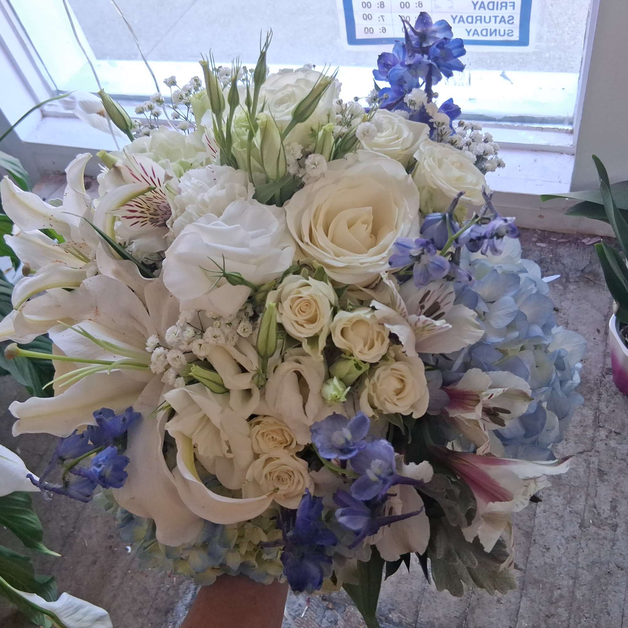Magnificent white oriental lily, garden roses, white lisiantus, blue hydrangea and delphinium