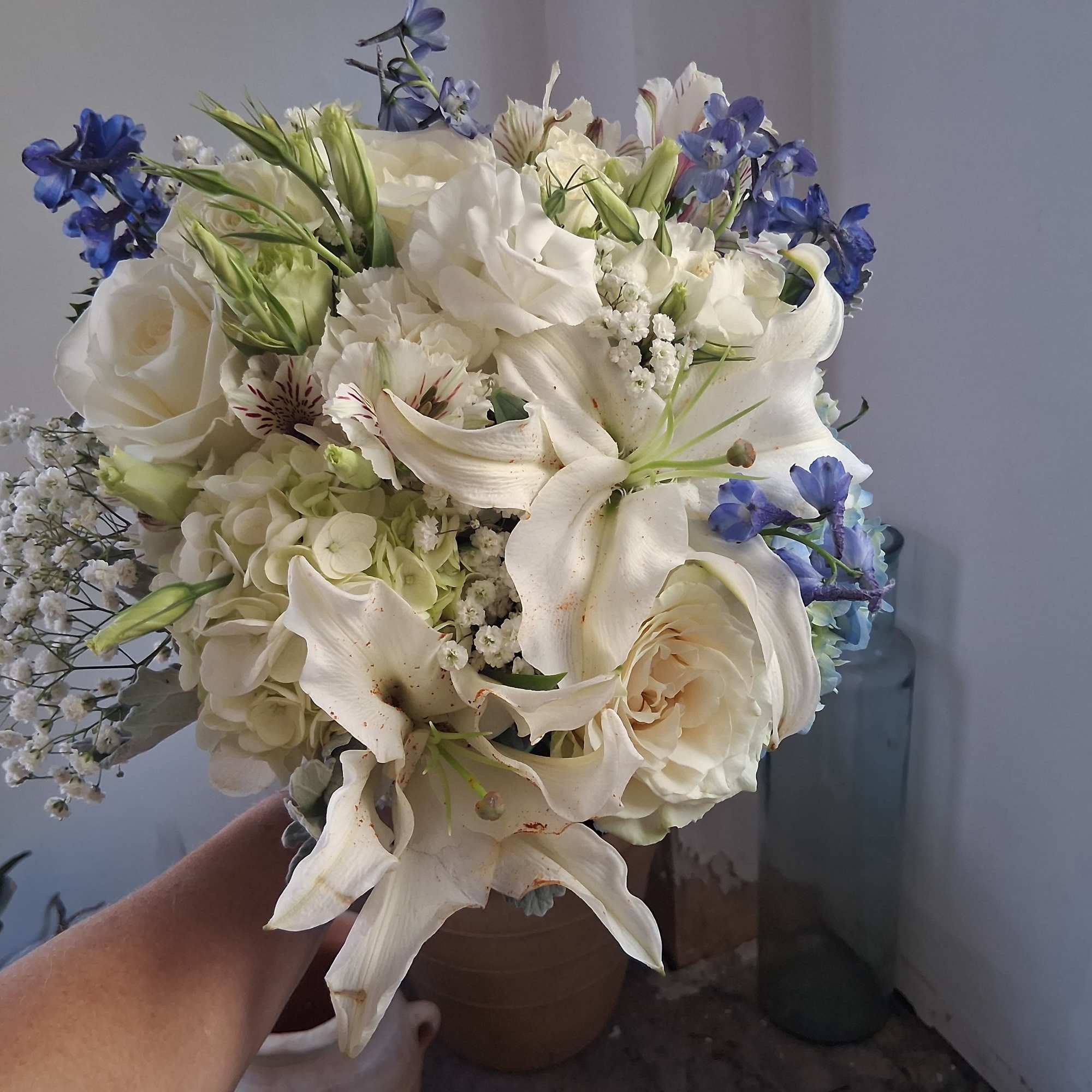 Magnificent white oriental lily, garden roses, white lisiantus, blue hydrangea and delphinium
