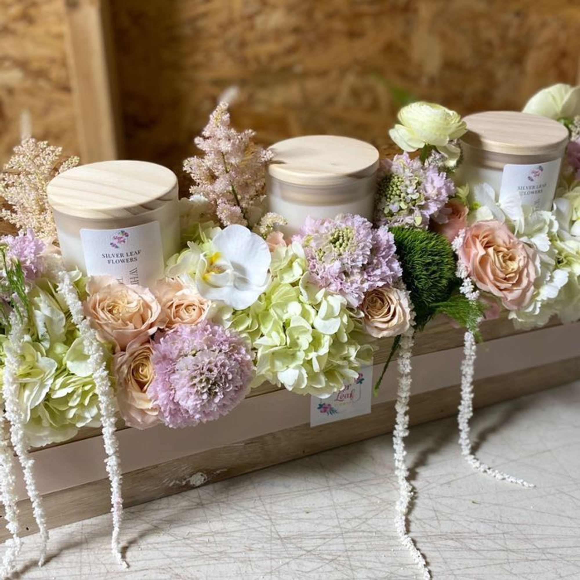 wood box filled with seasonal flowers blooms with organic candles 