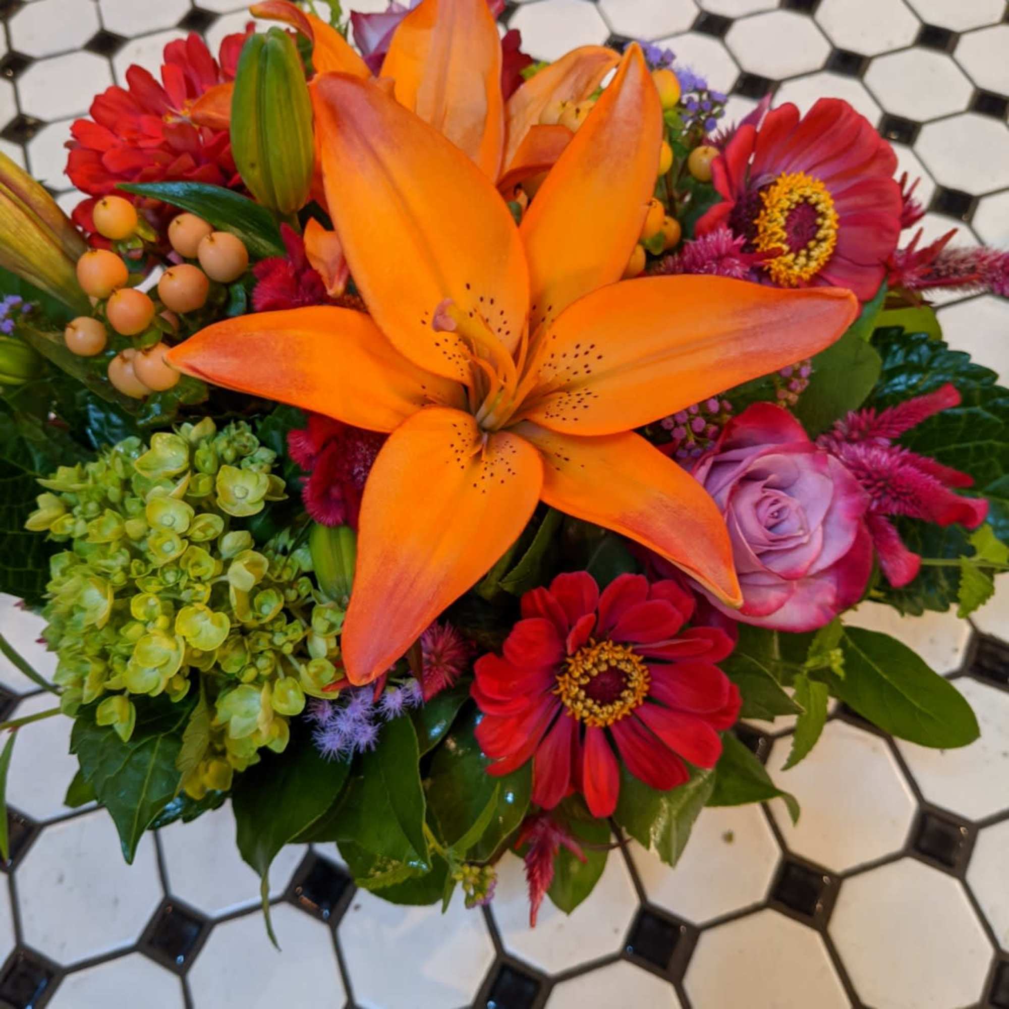 Fall colors abound from this compact and delightful floral design. Orange Lillies