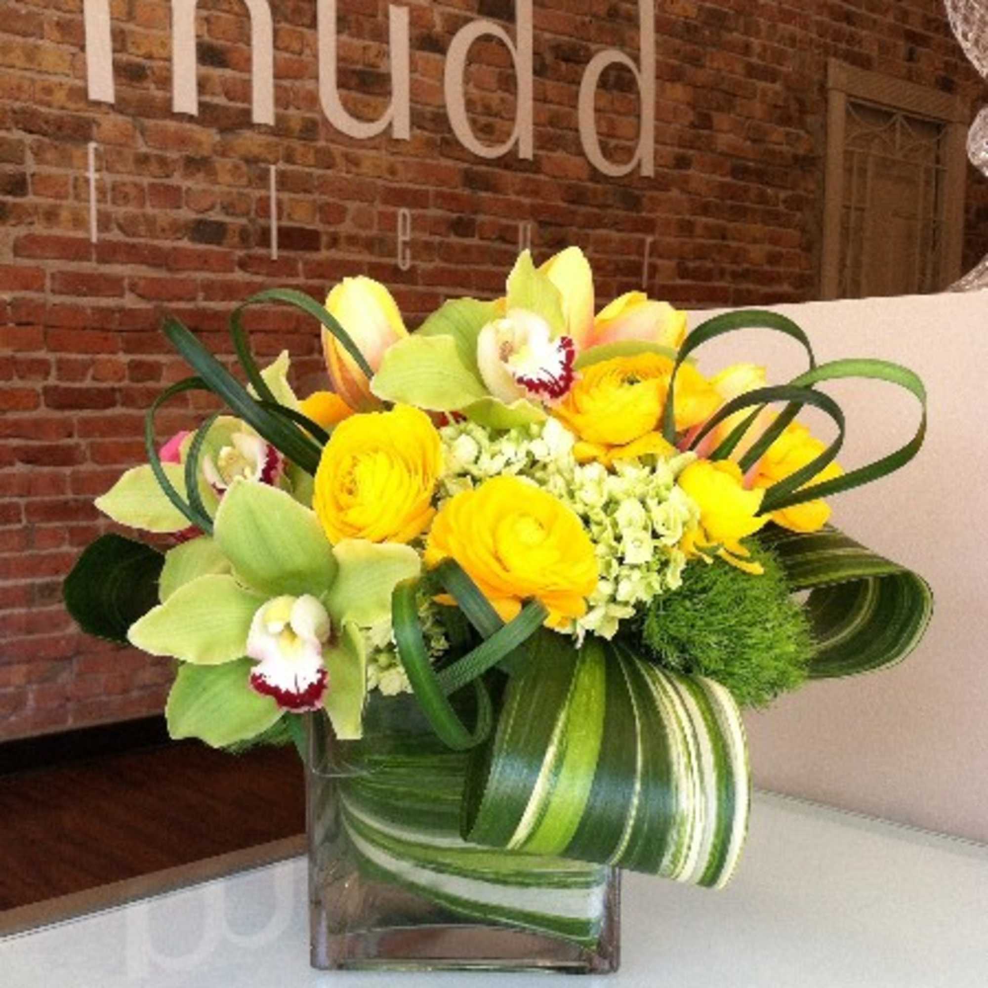 Green or yellow cymbidium orchids, green hydrangea, and dianthus detailed  here