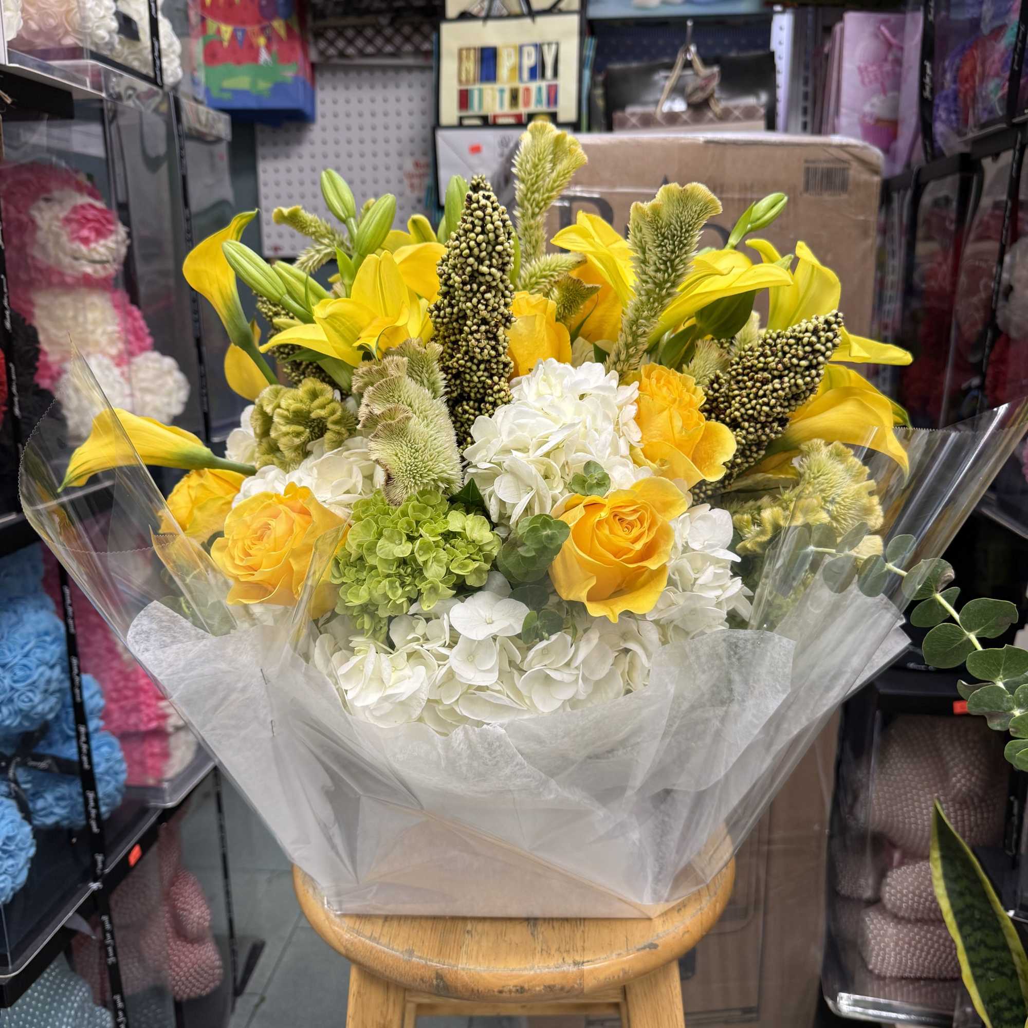Bright and uplifting, this arrangement combines vibrant yellow calla lilies, golden roses
