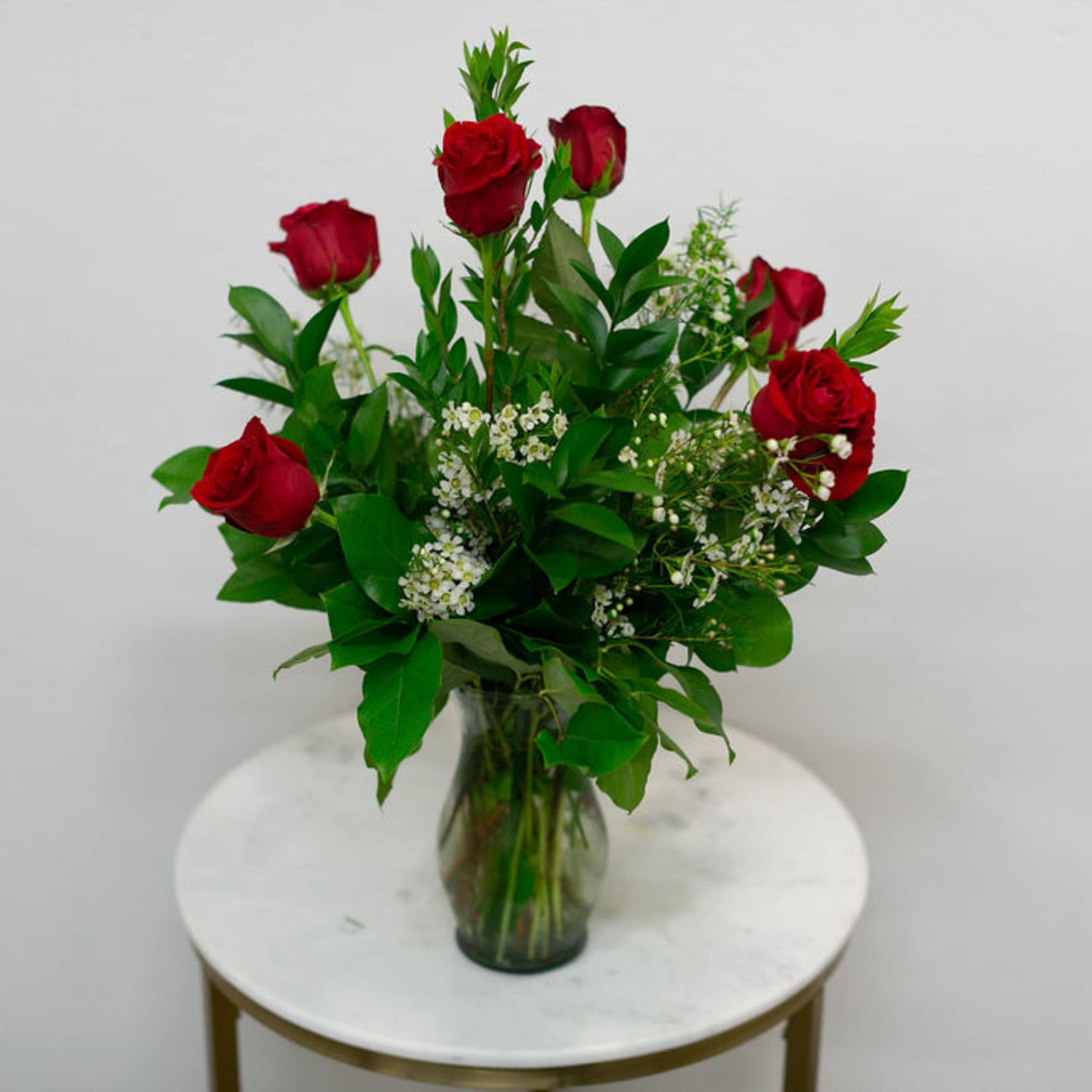 6 Red Roses arranged in with greenery and filler in a simple