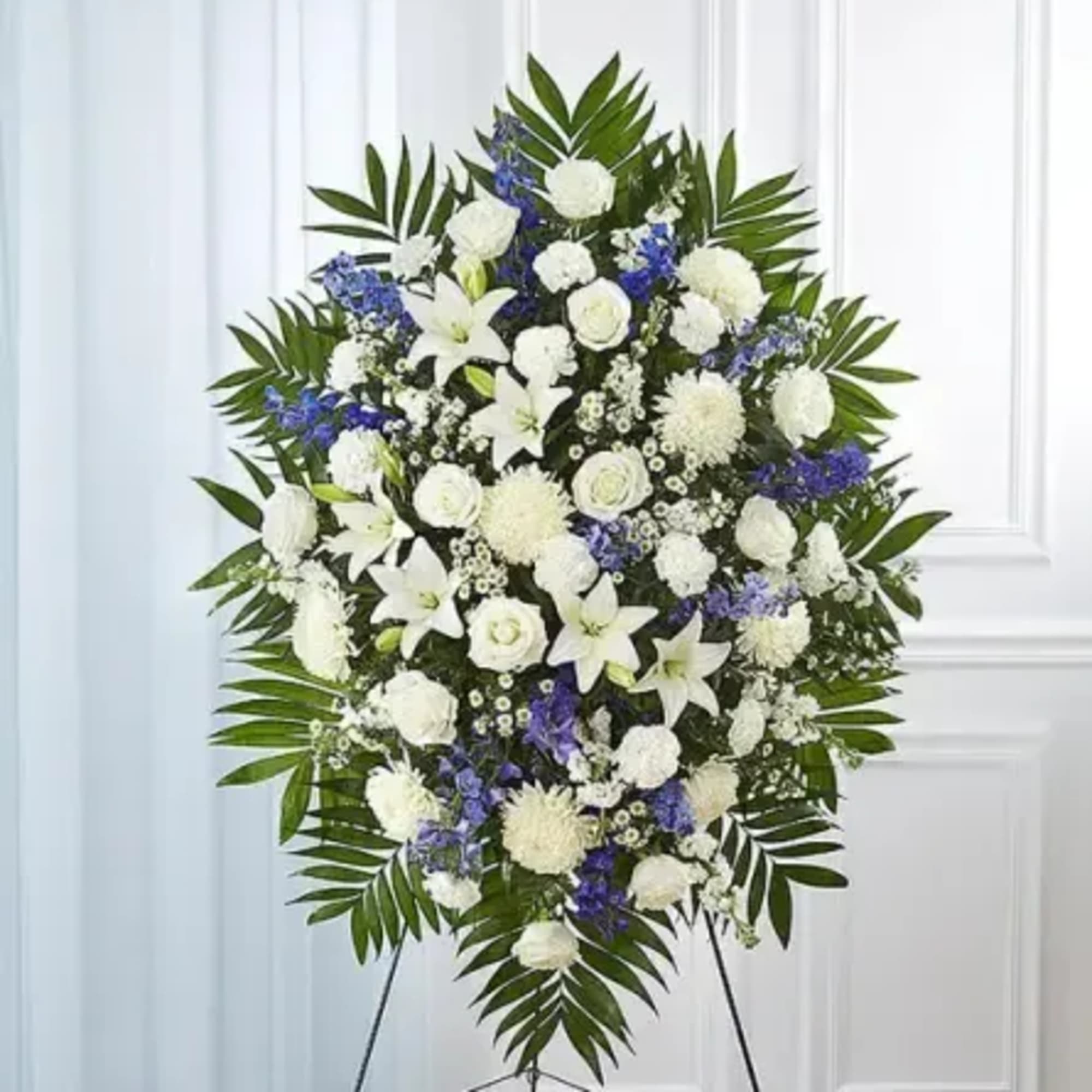 Offer a heartfelt tribute with this graceful blue and white standing spray