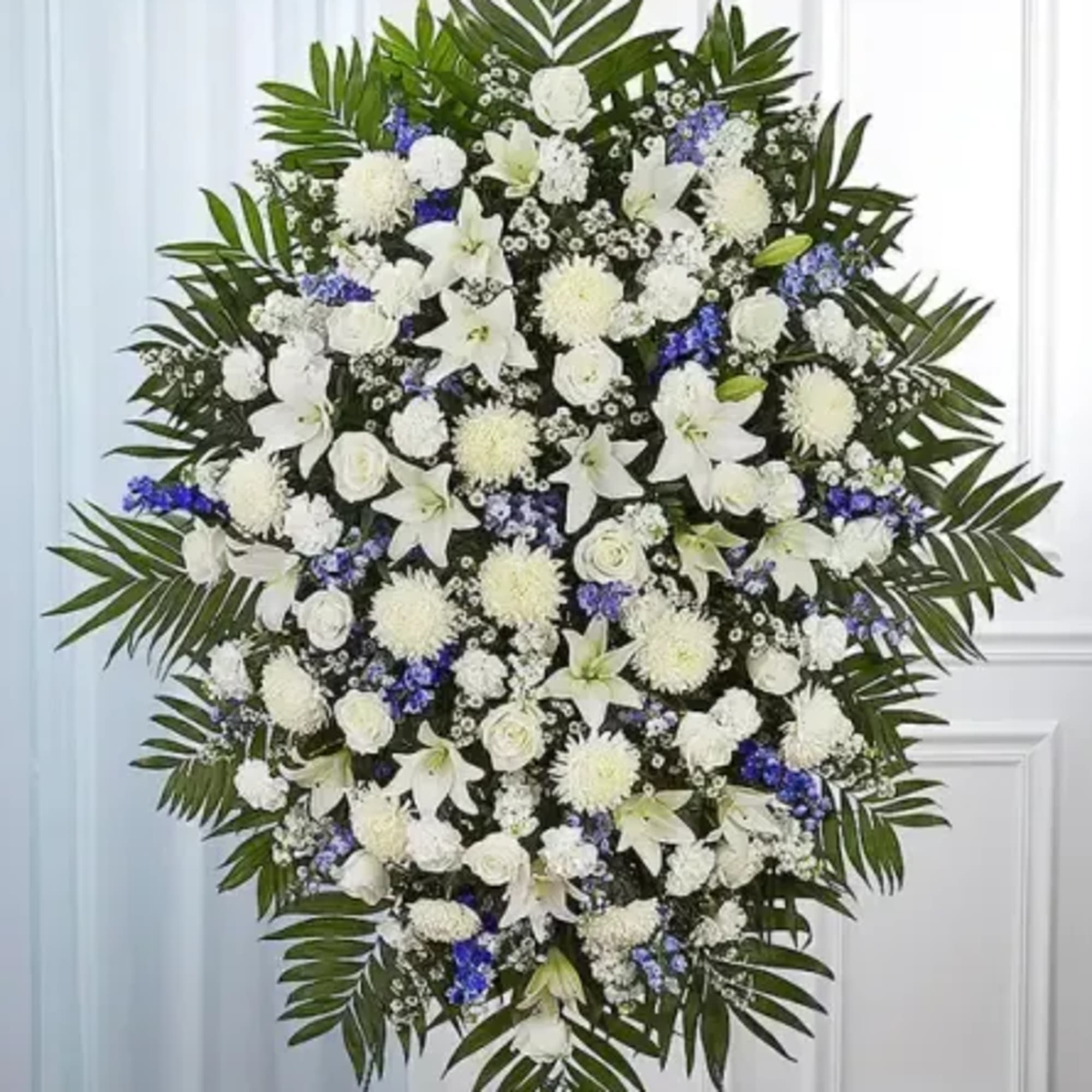 Offer a heartfelt tribute with this graceful blue and white standing spray