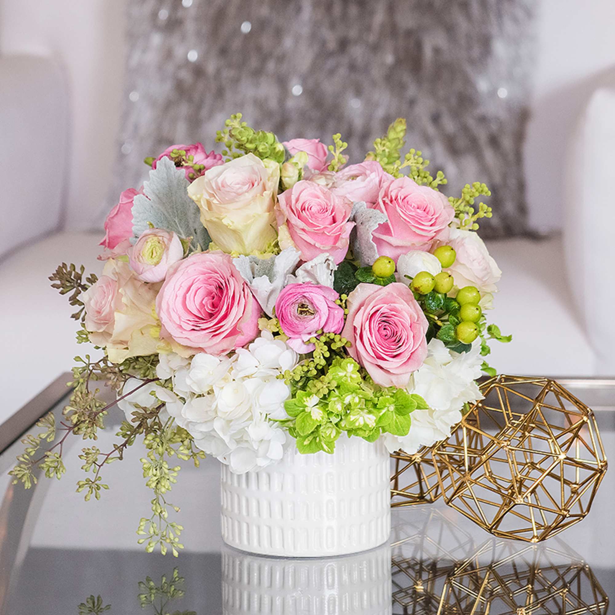A short and sweet arrangement of pink roses and pink ranunculus. The