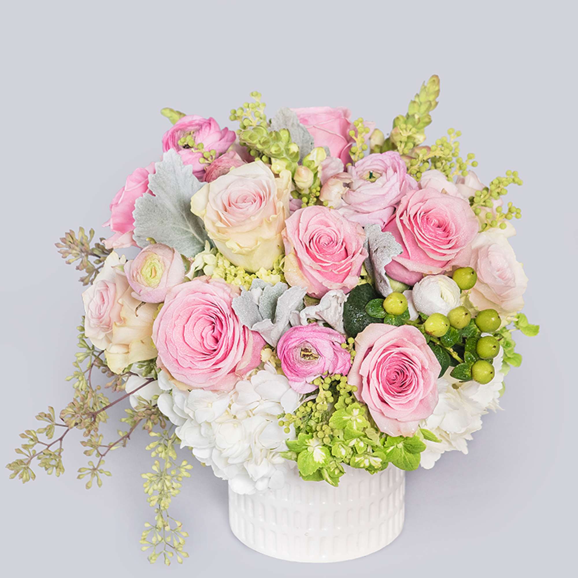 A short and sweet arrangement of pink roses and pink ranunculus. The