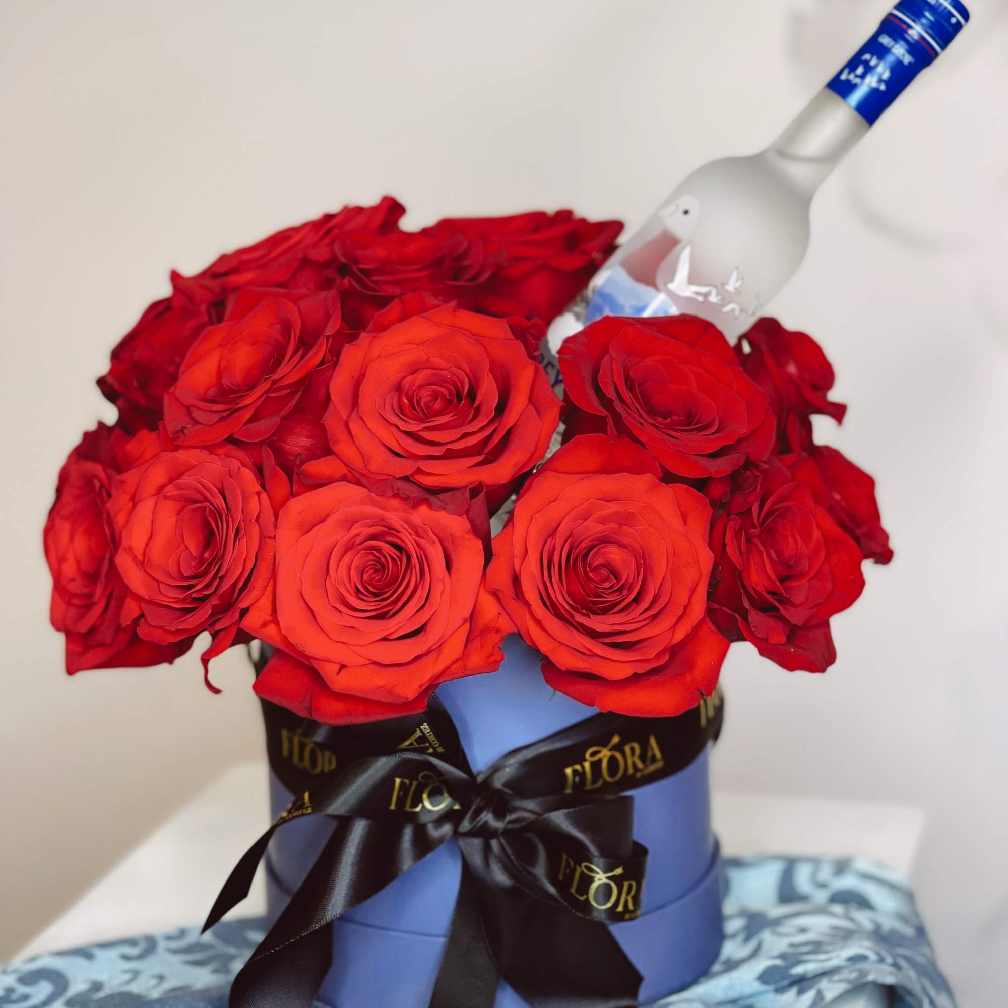 Make a bold statement with 70 red roses, a small Grey Goose