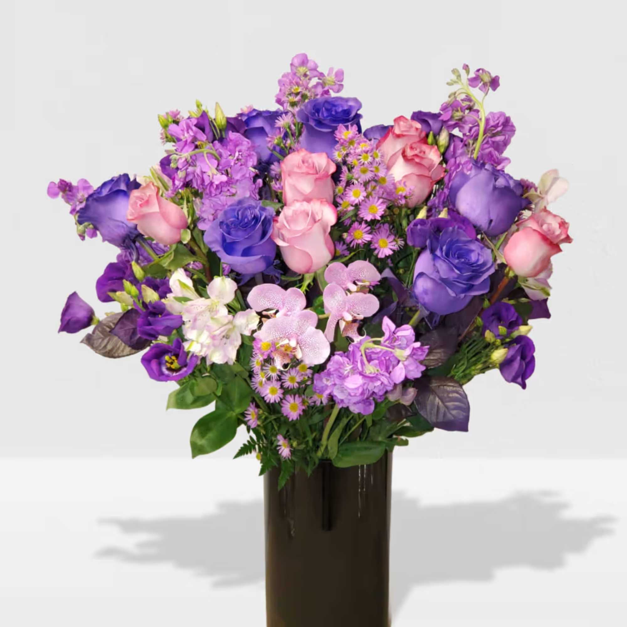 Cylinder vase with a mix of purple flowers  Cylinder vase with a mix of purple flowers