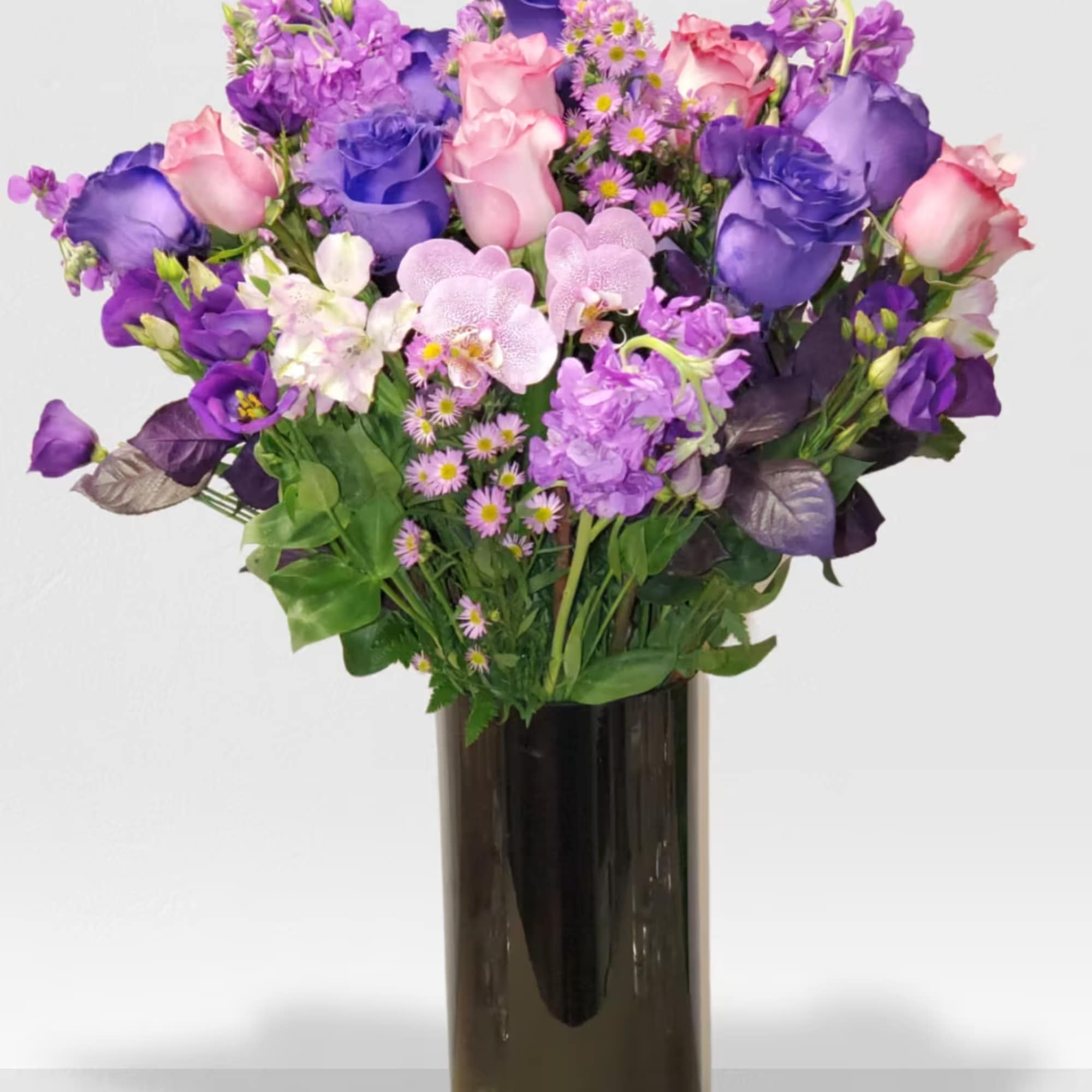 Cylinder vase with a mix of purple flowers  Cylinder vase with a mix of purple flowers