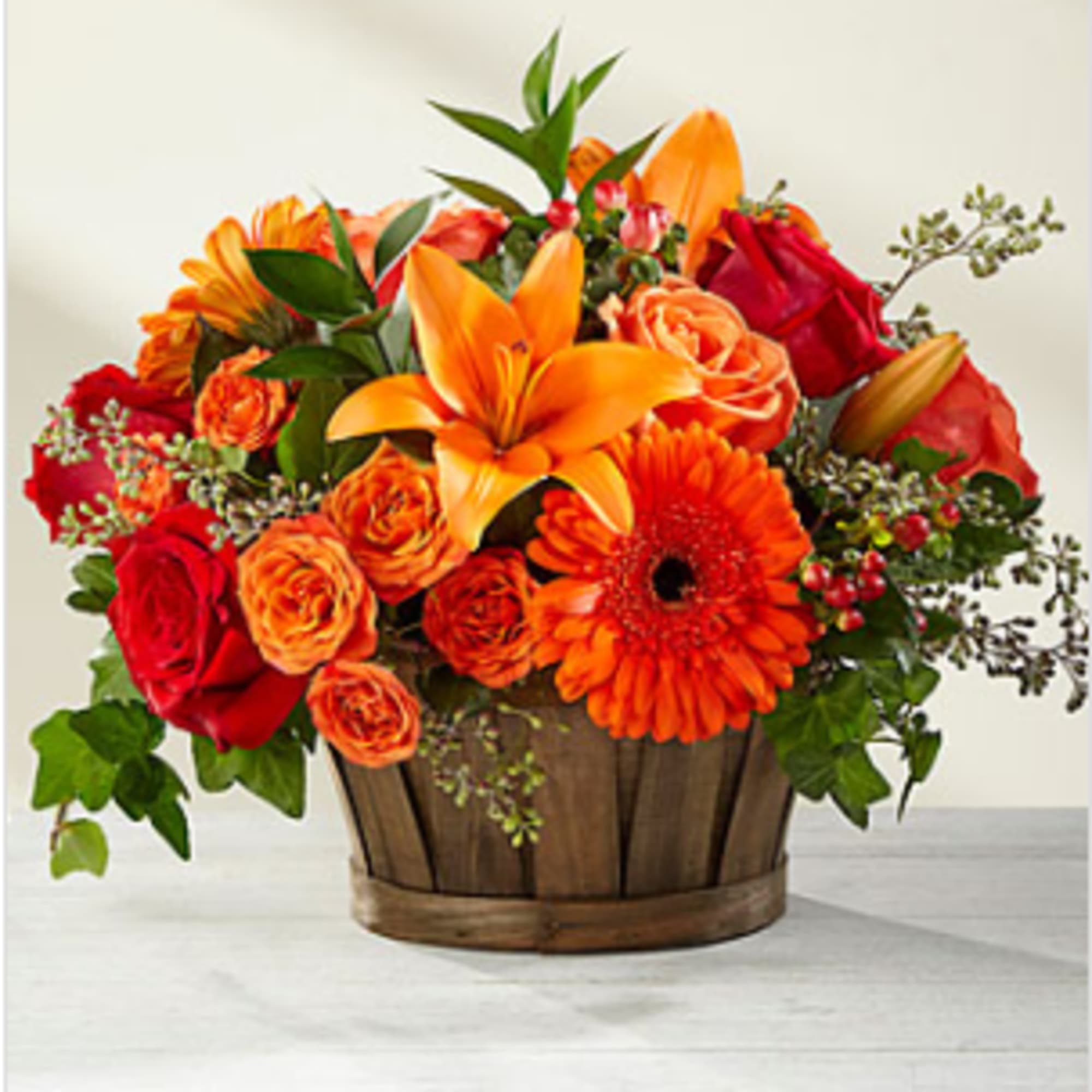 A truly gorgeous fresh flower arrangement, showcasing rich red roses, orange spray