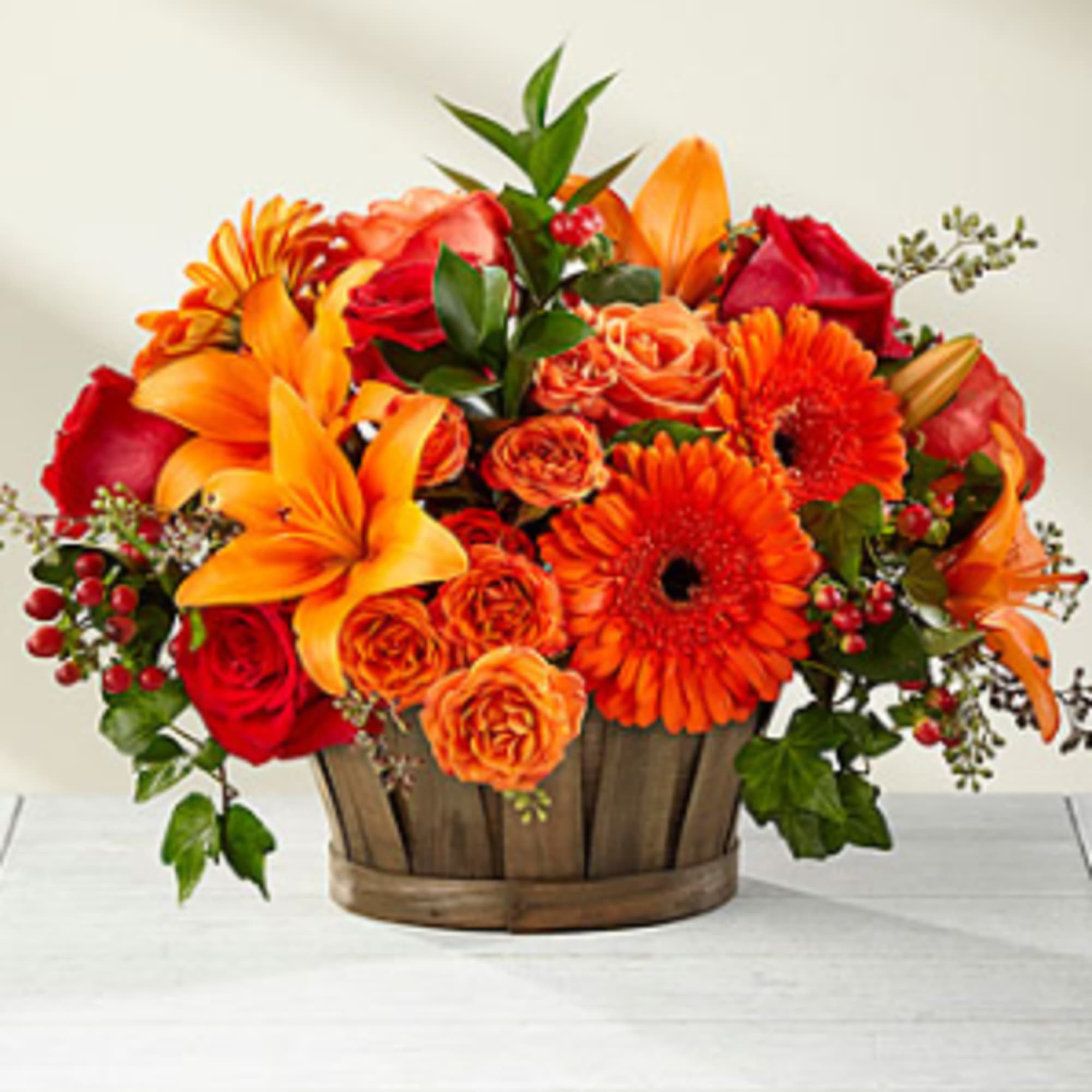 A truly gorgeous fresh flower arrangement, showcasing rich red roses, orange spray