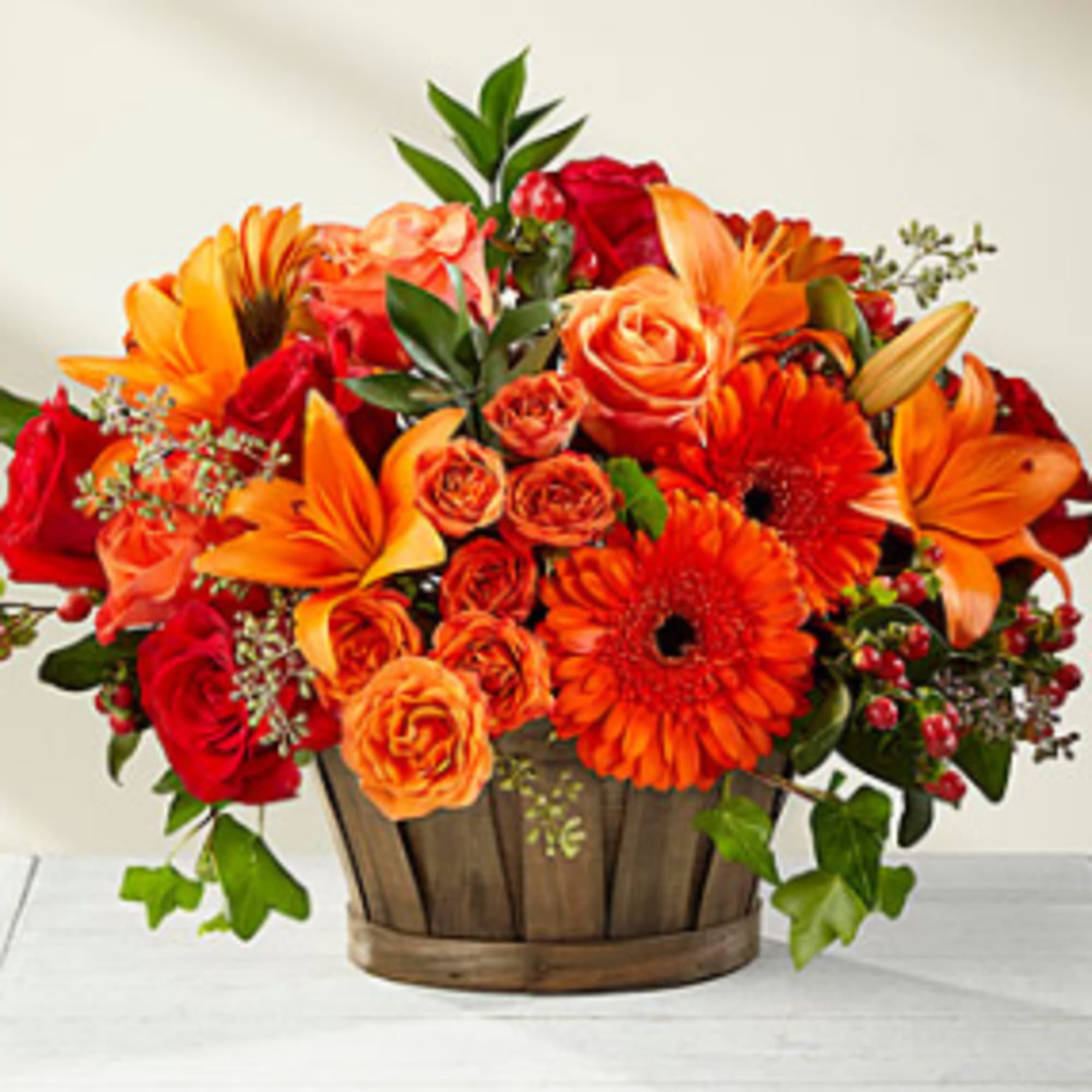 A truly gorgeous fresh flower arrangement, showcasing rich red roses, orange spray