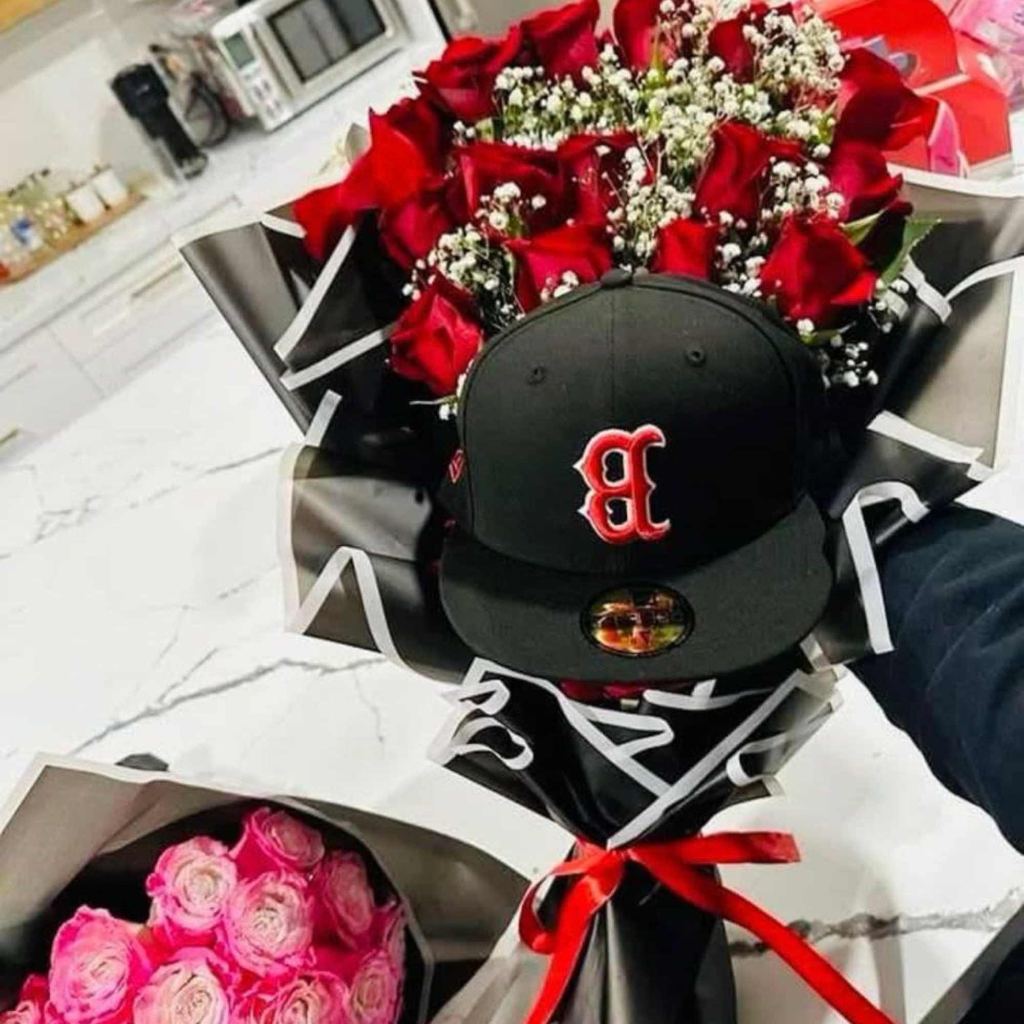 Elaborado con rosas rojas,  gipsofilia y una gorra