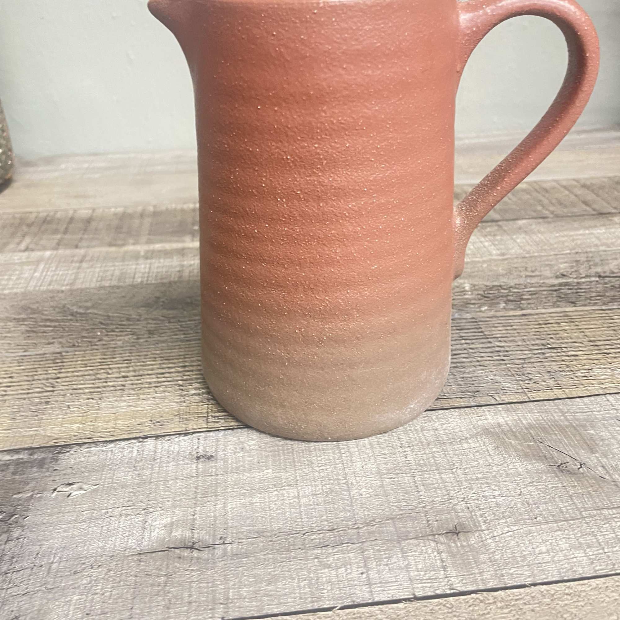 A reusable stoneware pitcher filled with seasonal blooms. This keepsake container is