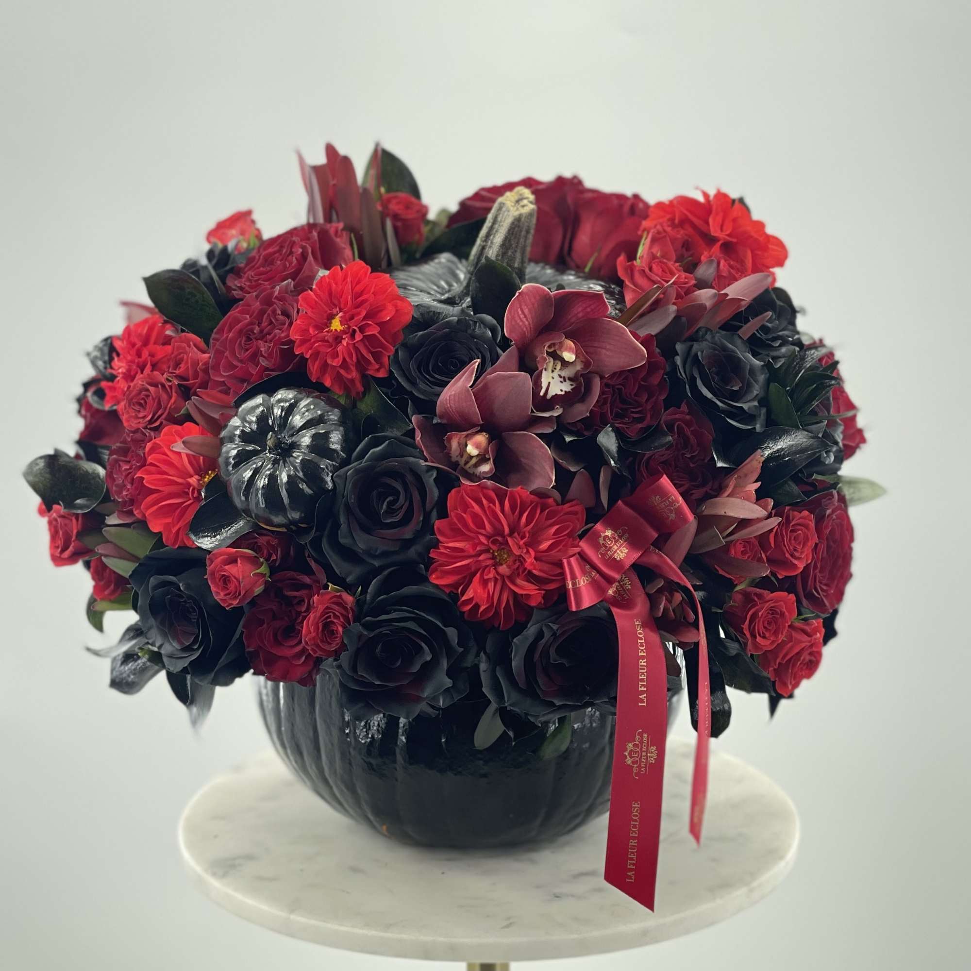 Mix of  red flowers in the  black pumpkin 