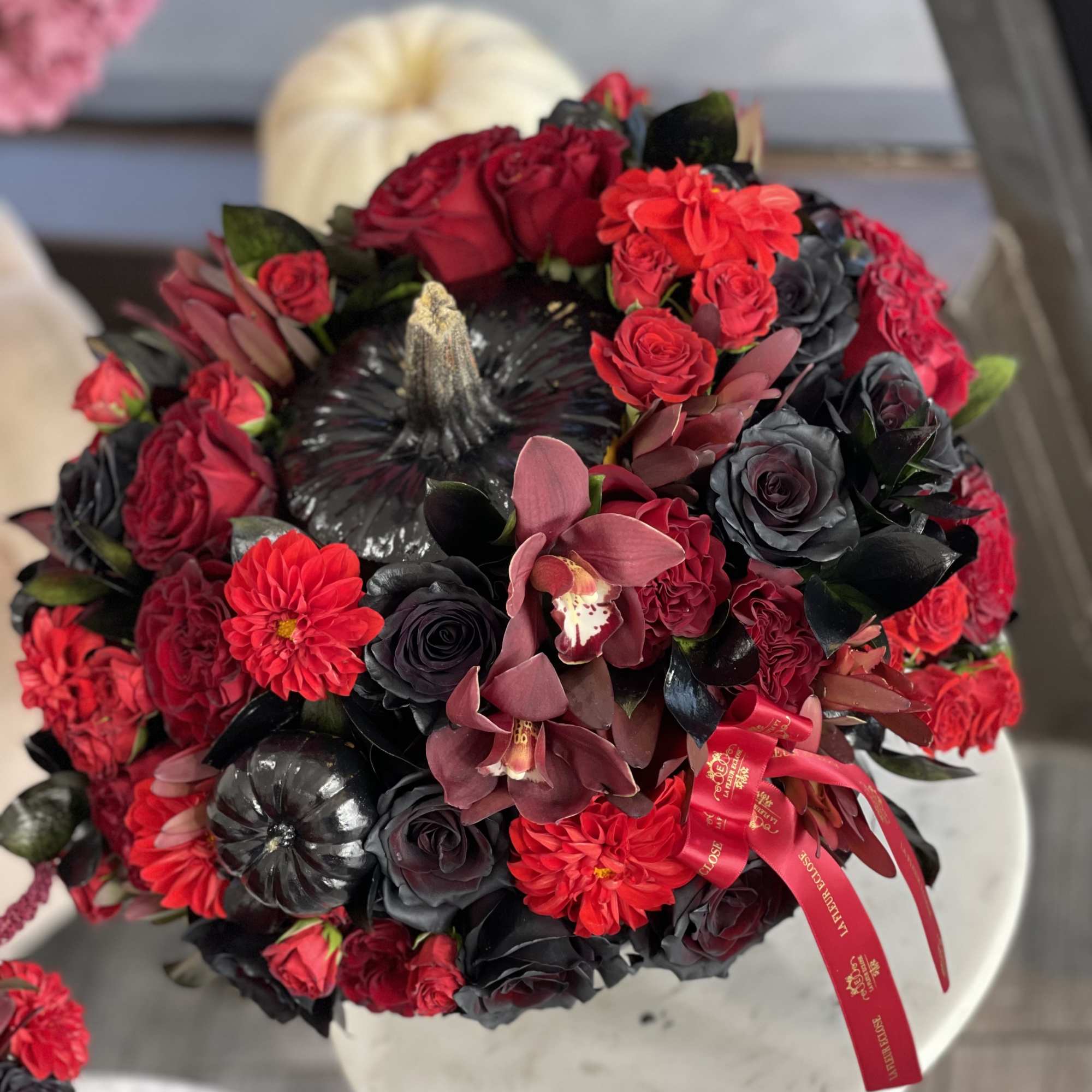 Mix of  red flowers in the  black pumpkin 