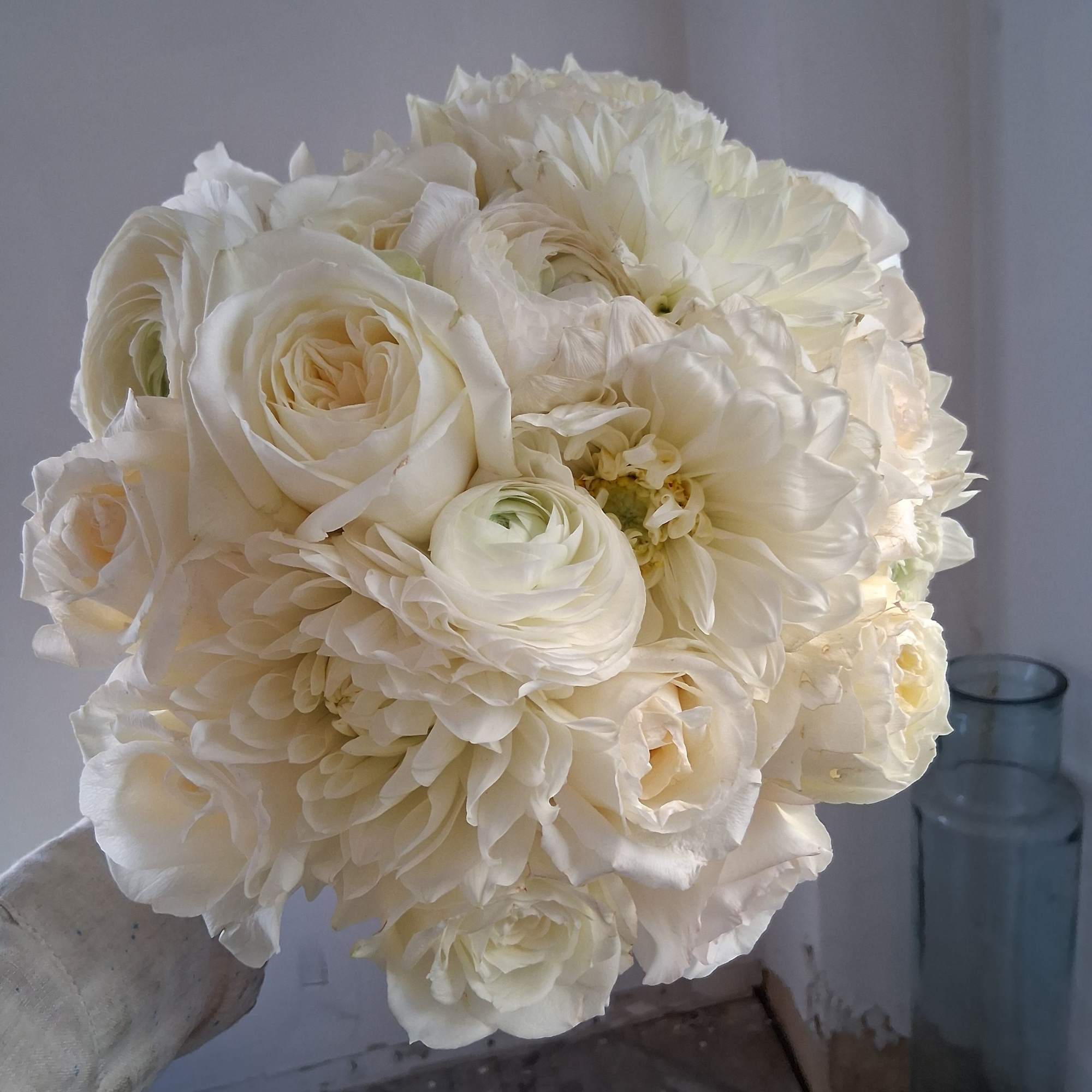 Gorgeous pure white classical round bridal bouquet of standard and garden roses