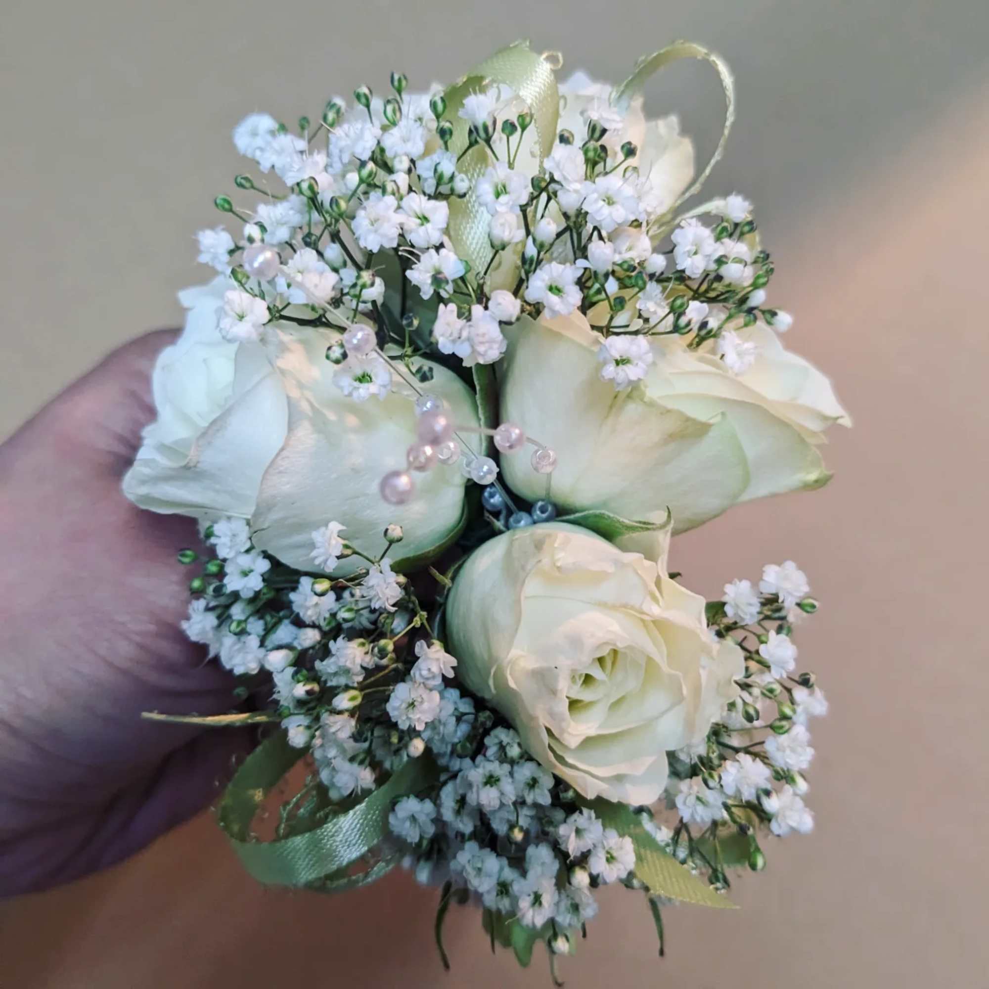 A classic white corsage with some ribbons, this wrist arrangement looks good