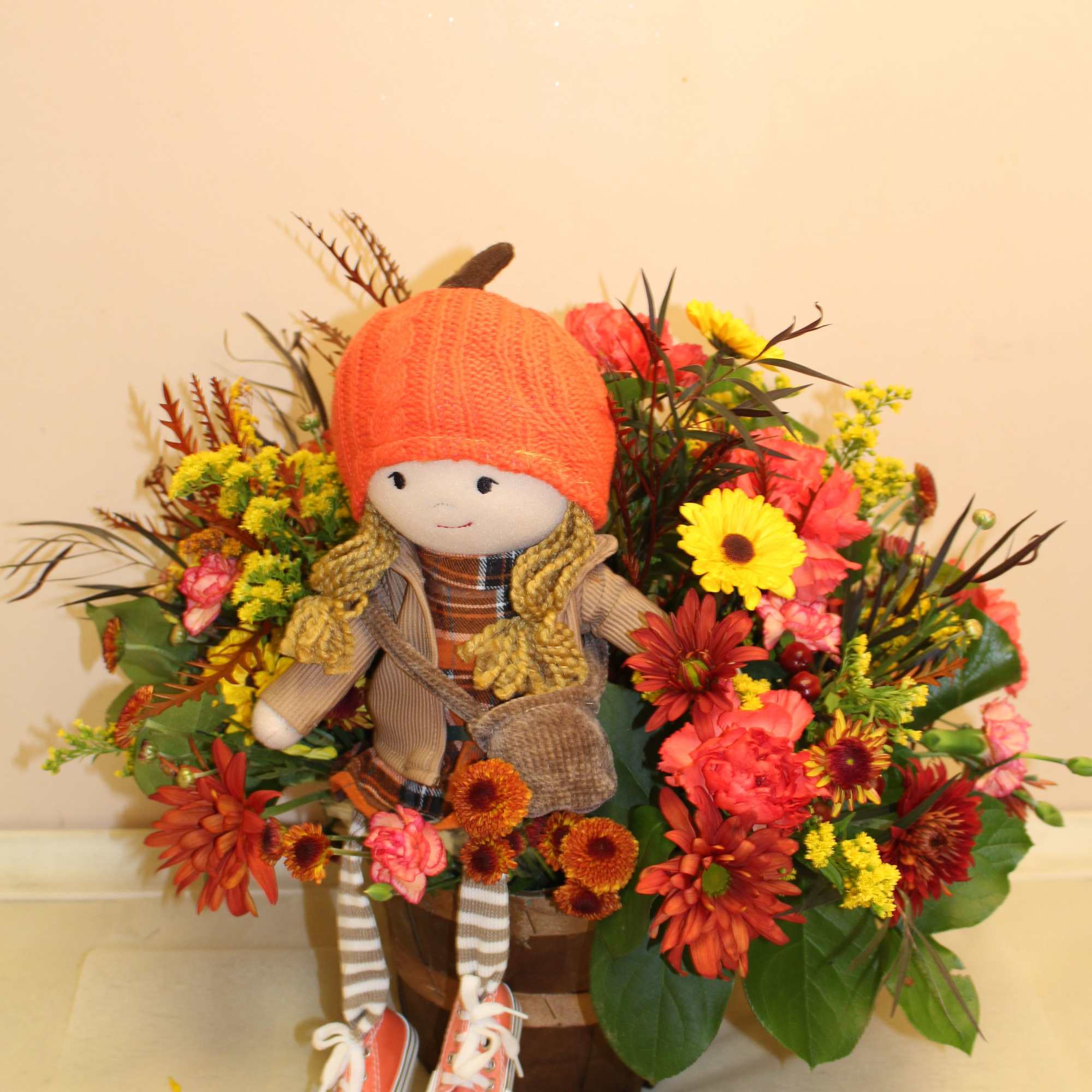 an autumn arrangement with pretty patty sitting amongst the flowers  
Standing