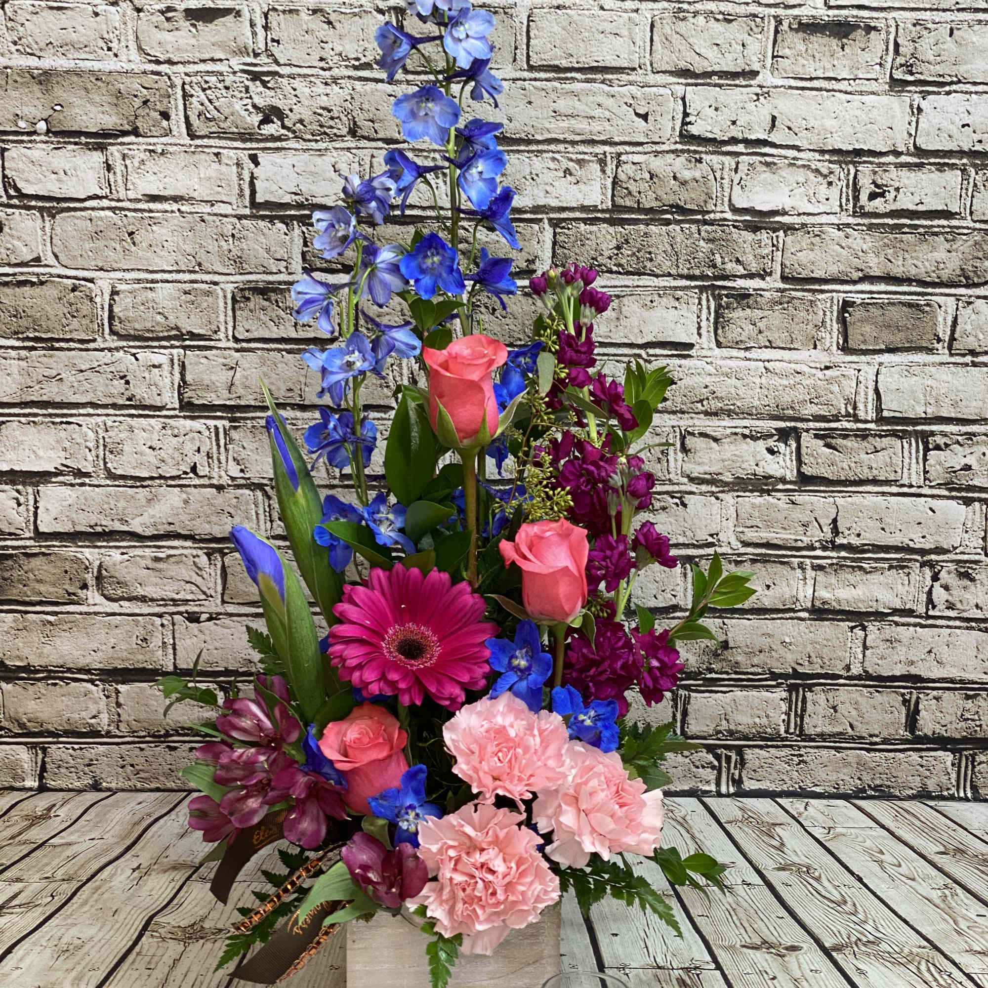 This elegant sympathy arrangement blends soothing shades of blue, gentle lavender, and This elegant sympathy arrangement blends soothing shades of blue, gentle lavender, and