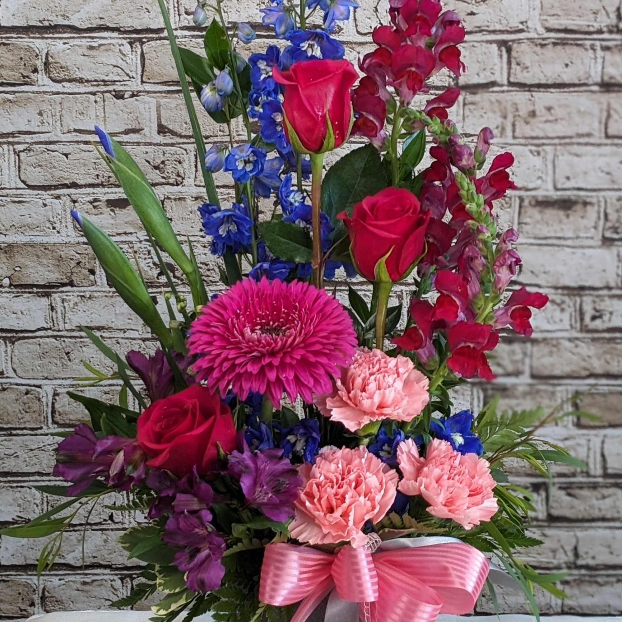 This elegant sympathy arrangement blends soothing shades of blue, gentle lavender, and This elegant sympathy arrangement blends soothing shades of blue, gentle lavender, and