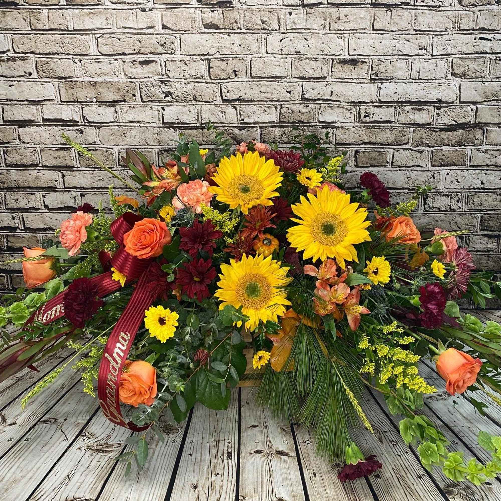 This vibrant casket spray offers a heartfelt expression of love and remembrance This vibrant casket spray offers a heartfelt expression of love and remembrance