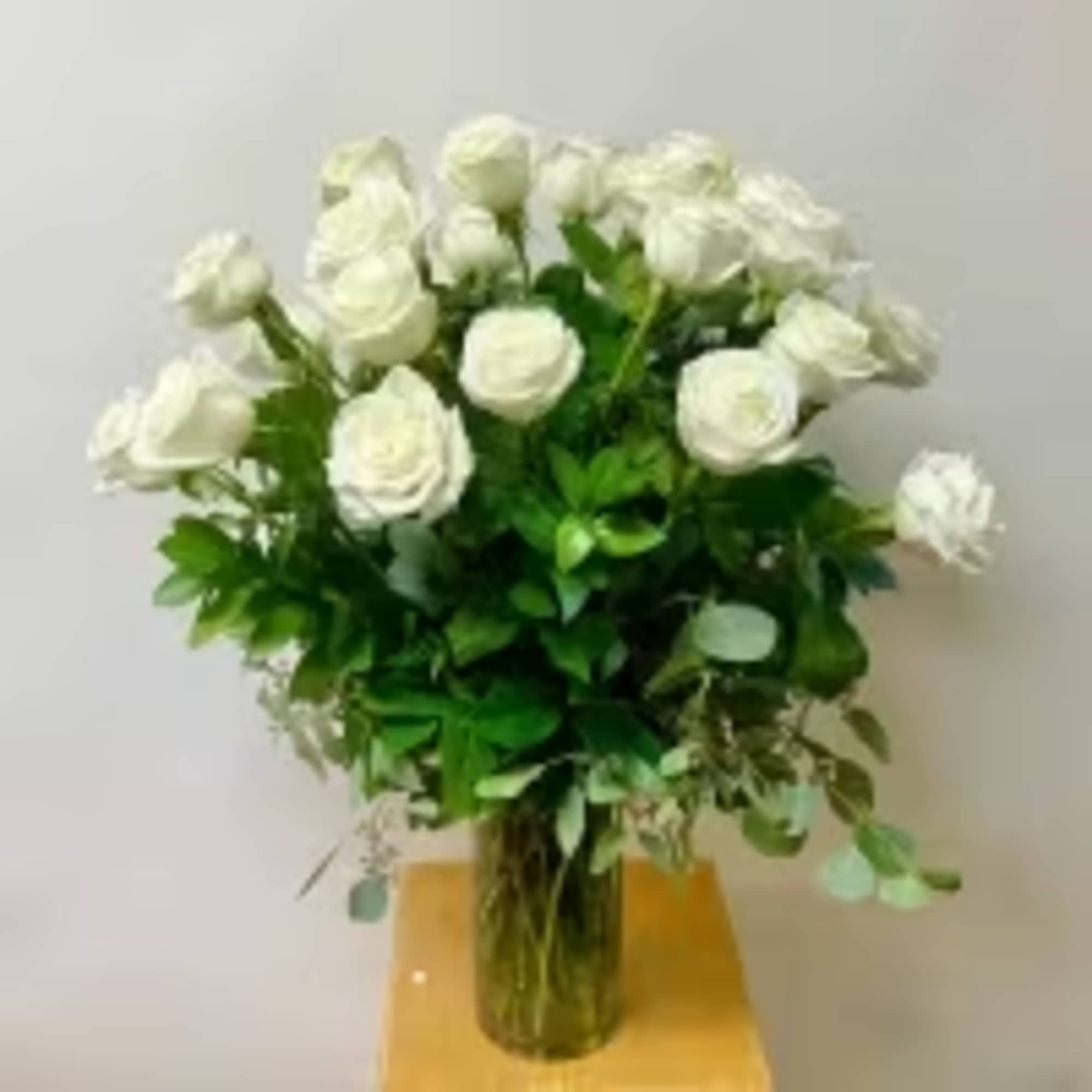 White Roses with Greenery Arranged in a Glass Vase. 