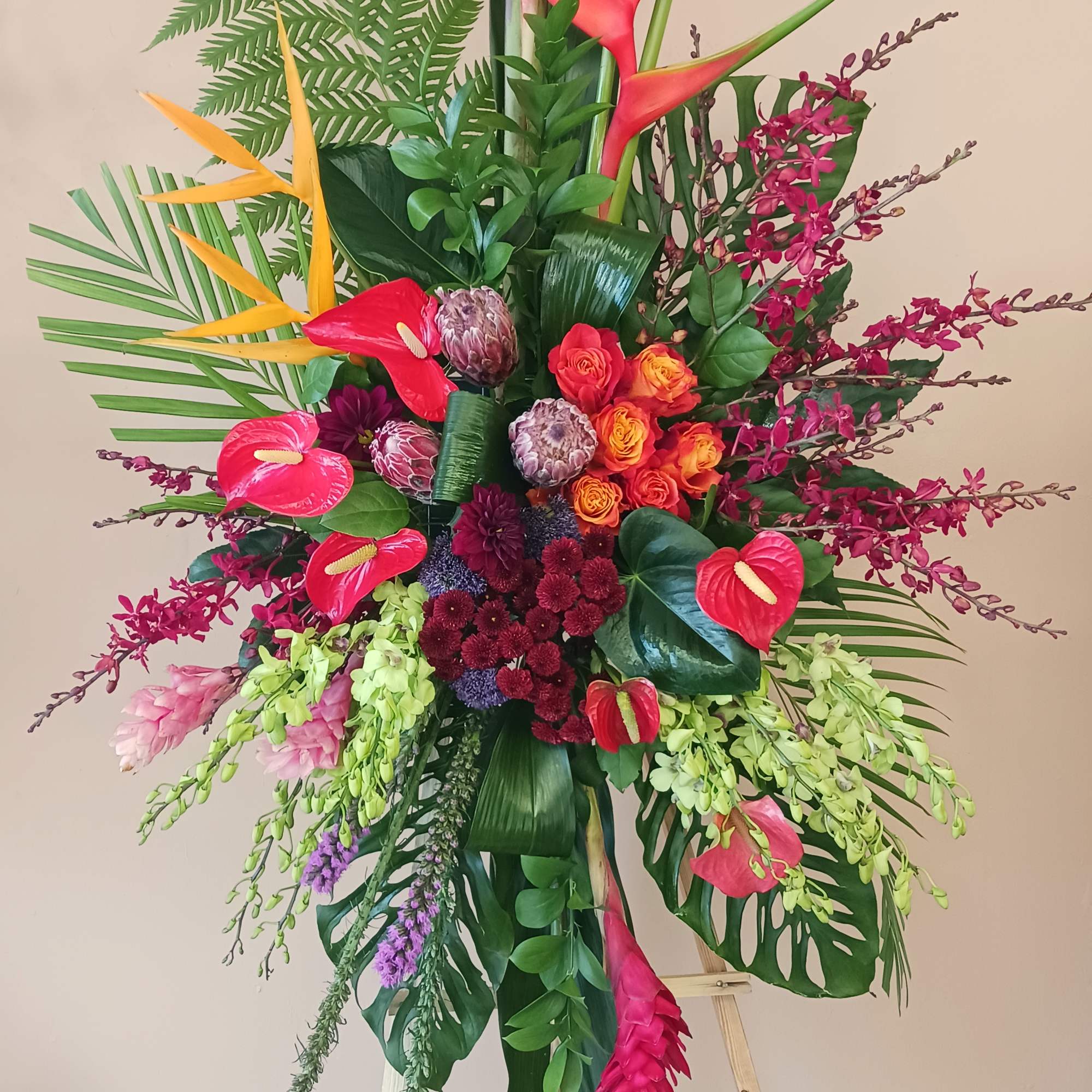 Standing spray on a easel with bright tropical flowers