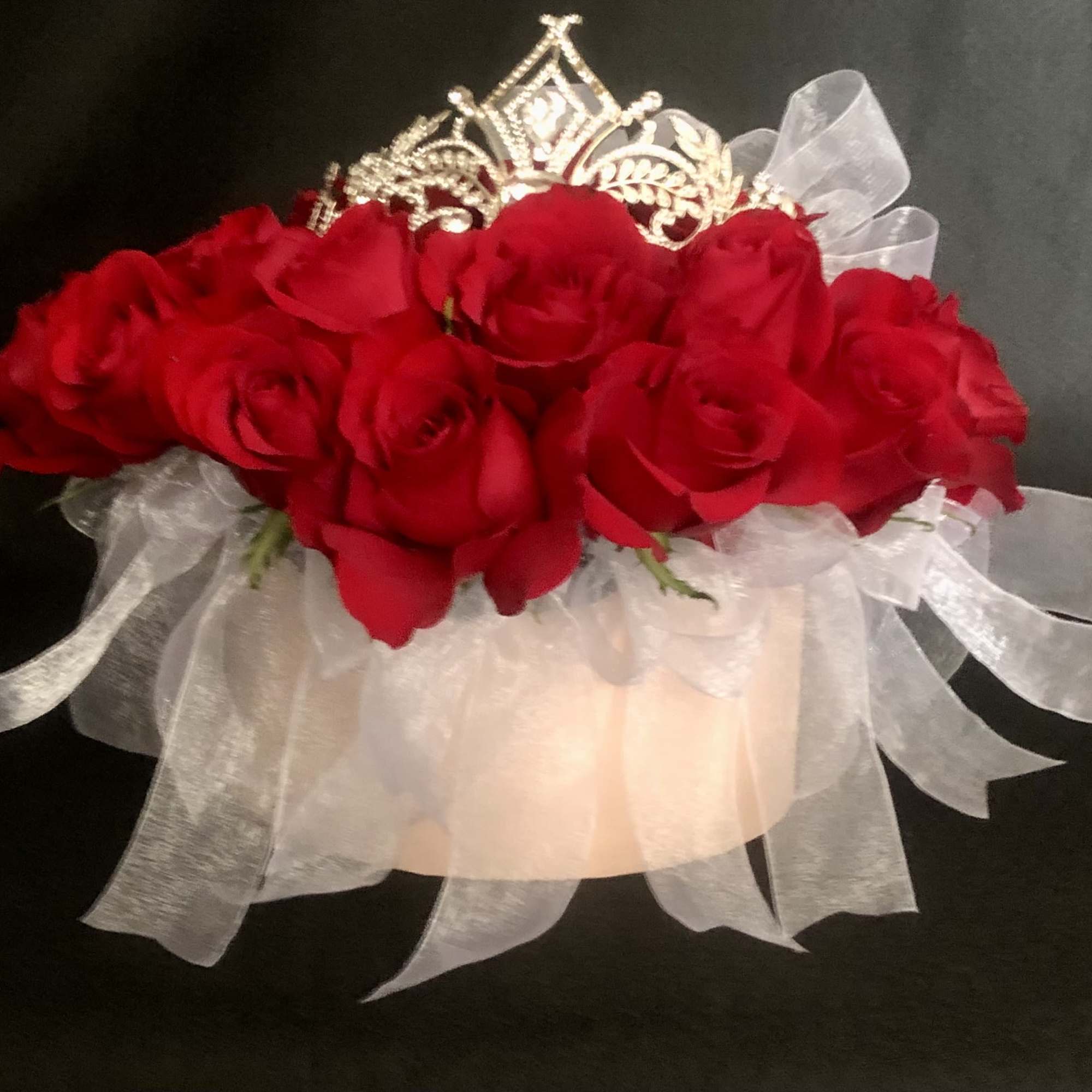 24 RED ROSES WITH RIBBON TIED TO THE OUTER STEMS, IN A