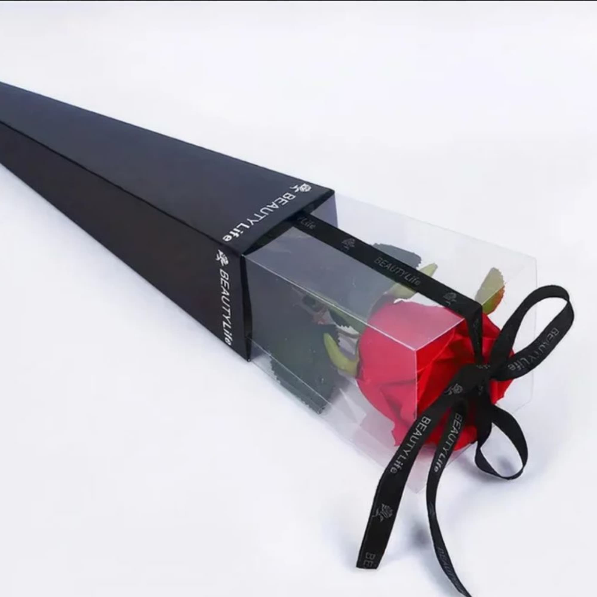 A single, radiant rose presented in a sleek black box topped with