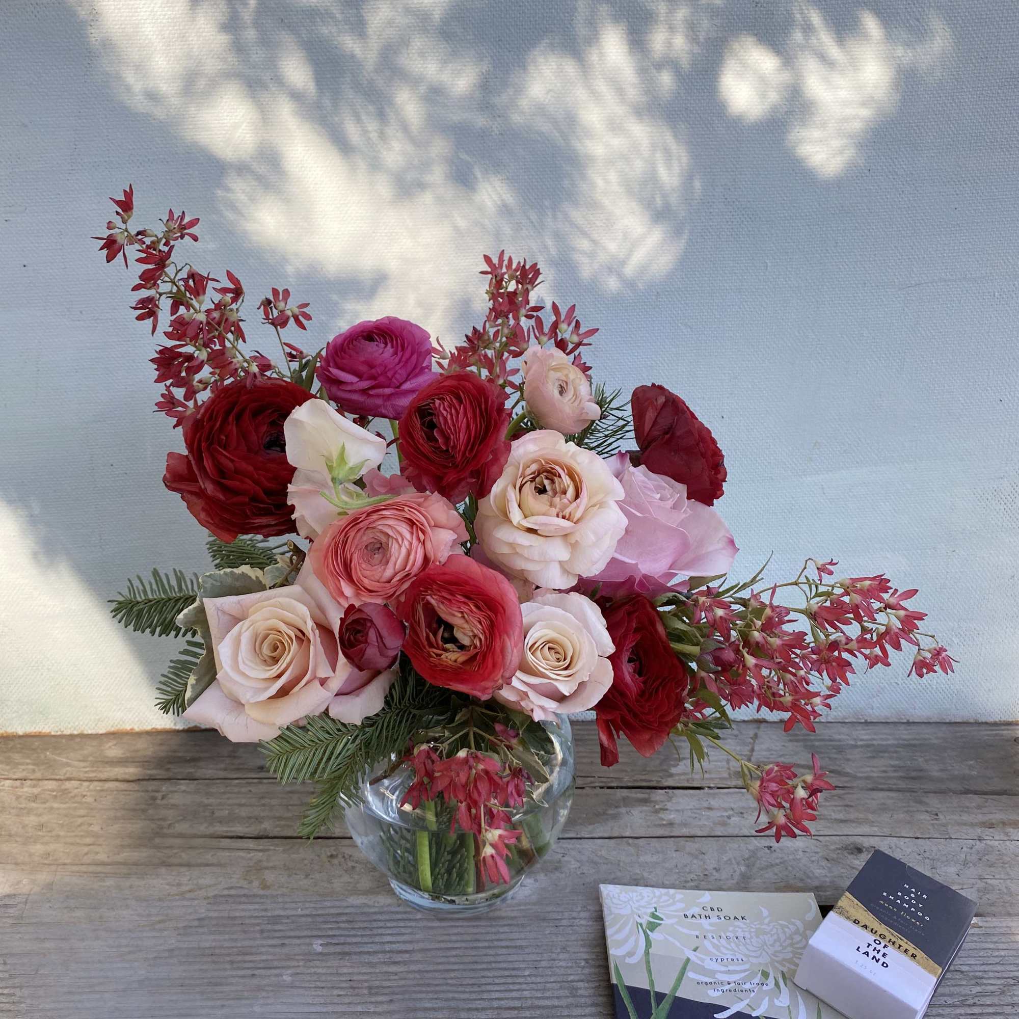 Beautiful warm blushing colors adorn this arrangement of ranunuclus, roses, and seasonal