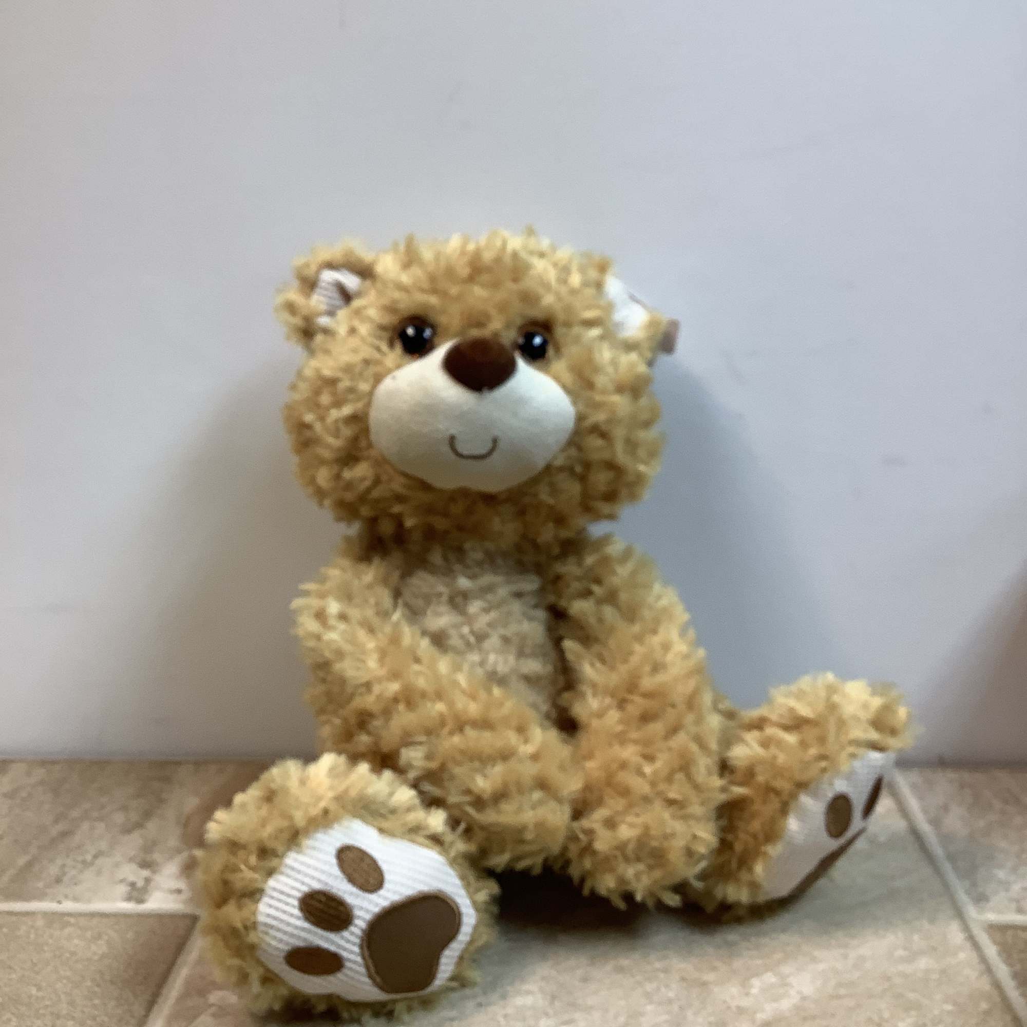 Willoughby is a very soft, tan-colored plush bear with a happy face.